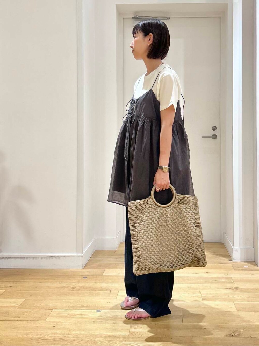 ブルー系のデニムパンツ、ホワイト系のTシャツ/カットソー、シルバー系のサンダルを着用したレディースの夏コーディネートの5枚目の写真