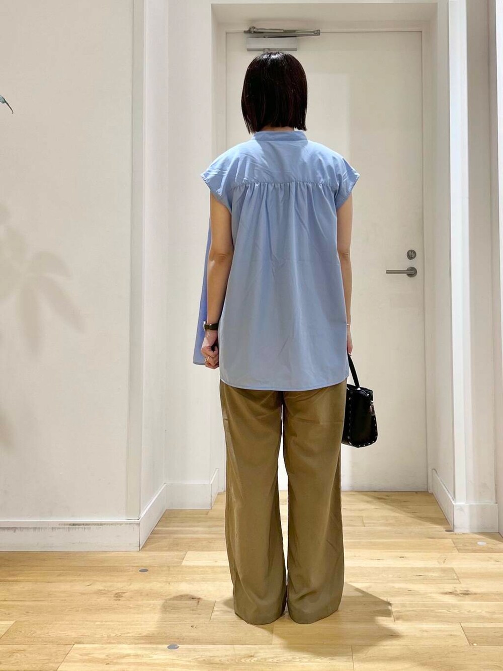 ブラック系のサンダル、ブラック系のショルダーバッグ、ブルー系のシャツ/ブラウスを着用したレディースの夏コーディネートの5枚目の写真