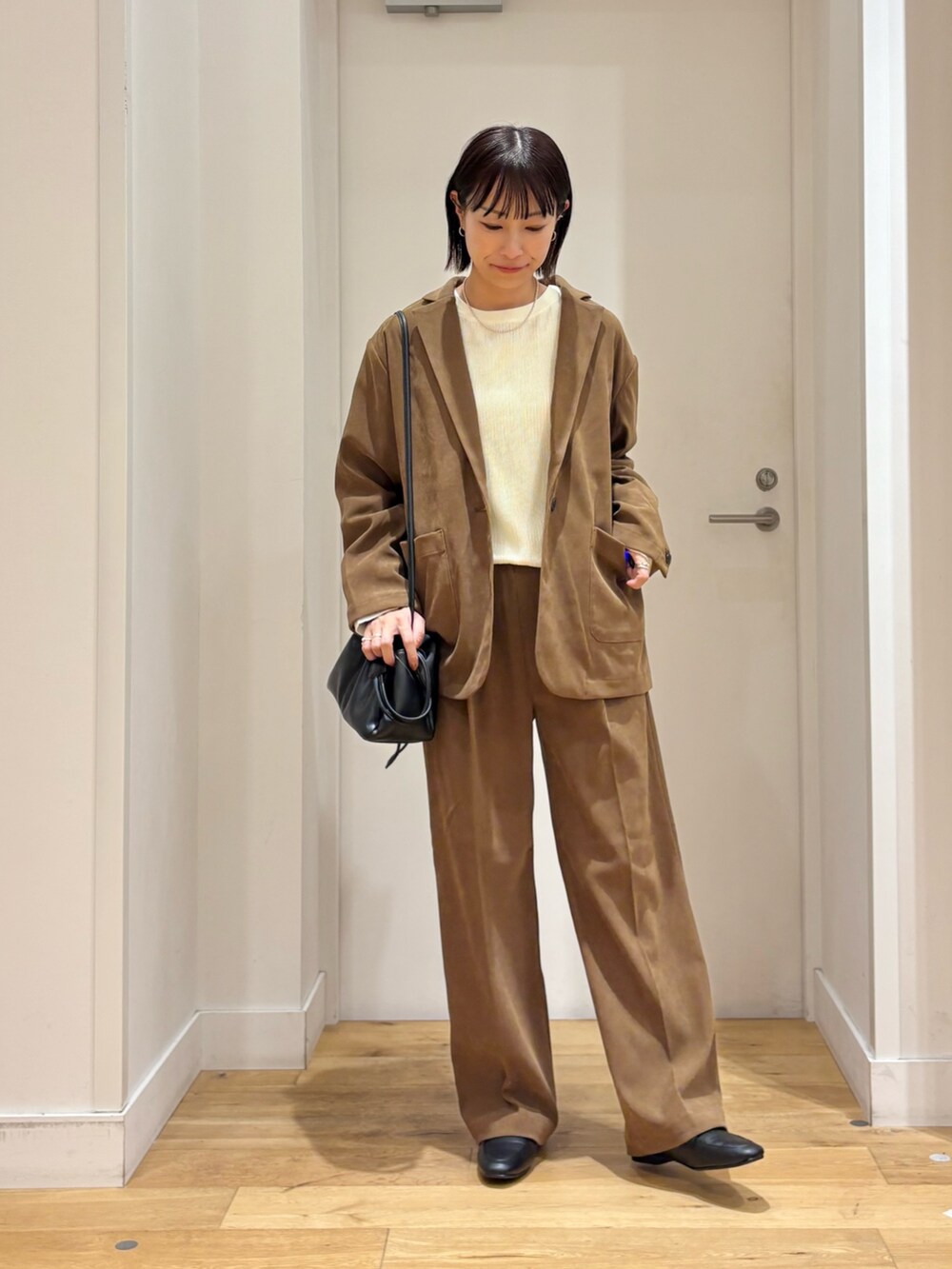 ベージュ系のその他アウター、ホワイト系のTシャツ/カットソー、ベージュ系のその他パンツを着用したレディースの秋コーディネートの4枚目の写真