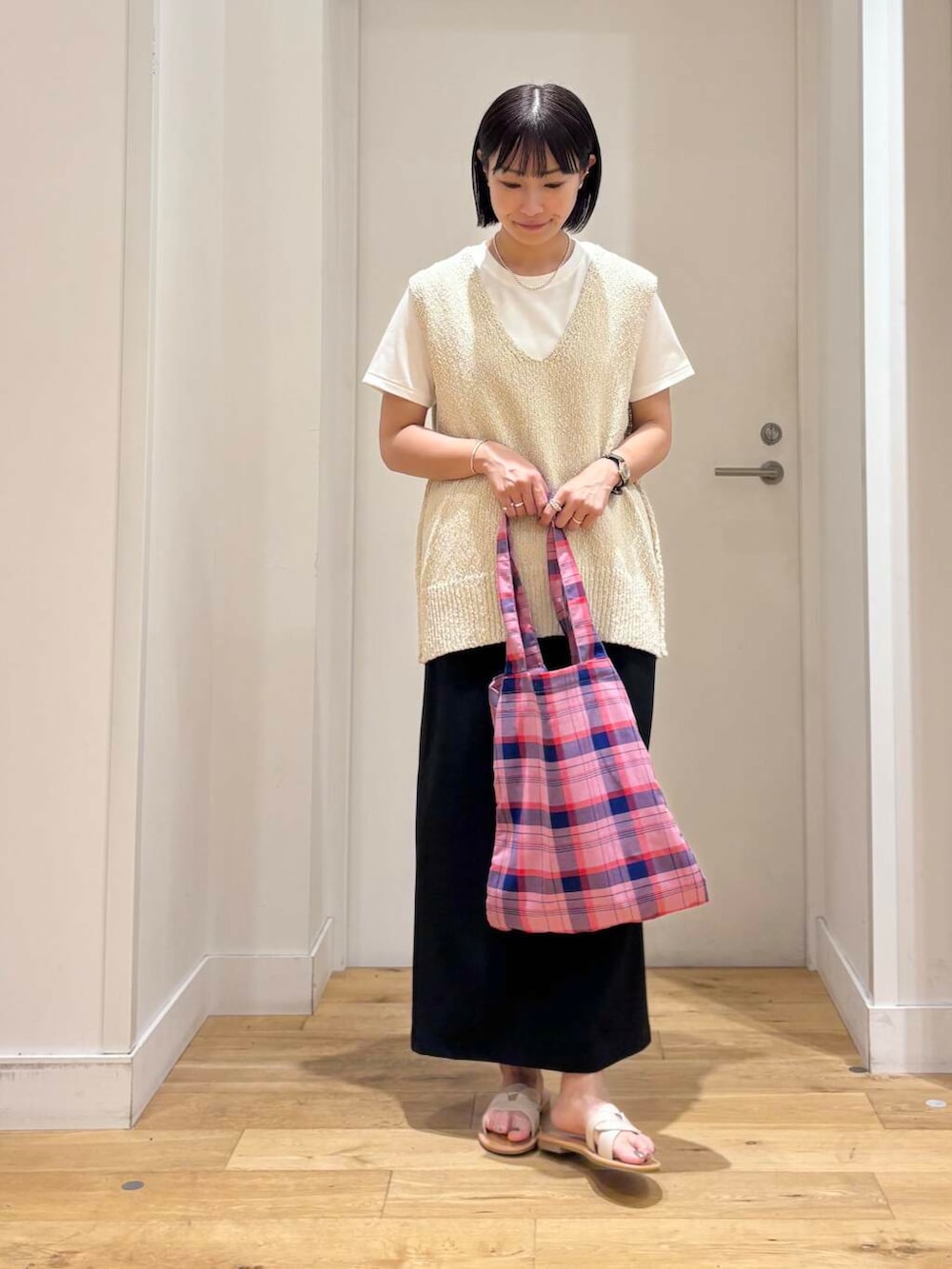 ホワイト系のサンダル、ホワイト系のTシャツ/カットソー、ブラック系のスカートを着用したレディースの夏コーディネートの3枚目の写真