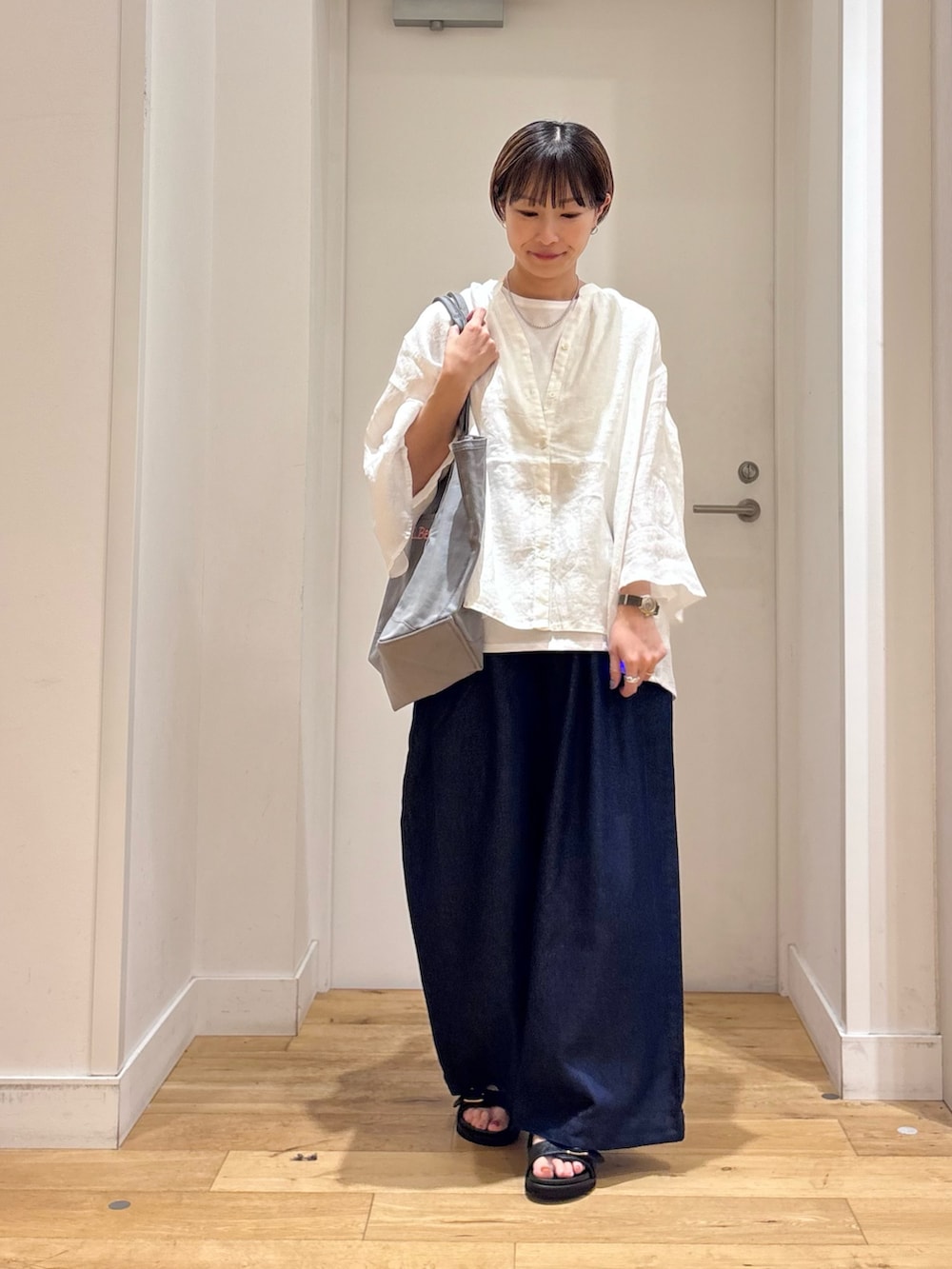 ホワイト系のシャツ/ブラウス、ホワイト系のタンクトップ、グレー系のトートバッグを着用したレディースの春コーディネートの2枚目の写真