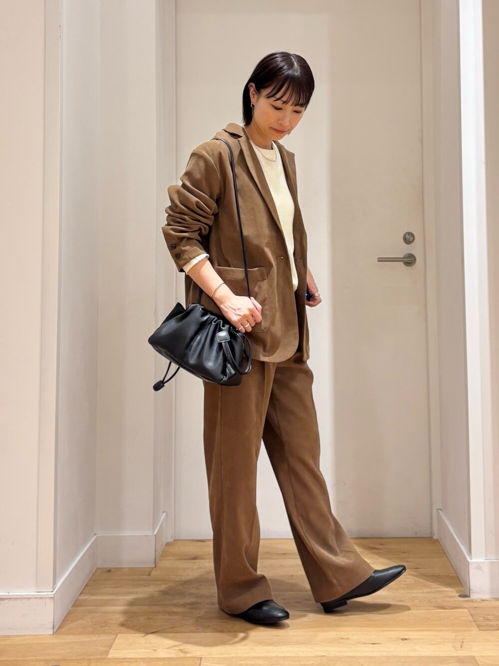 ベージュ系のその他アウター、ホワイト系のTシャツ/カットソー、ベージュ系のその他パンツを着用したレディースの秋コーディネートの5枚目の写真