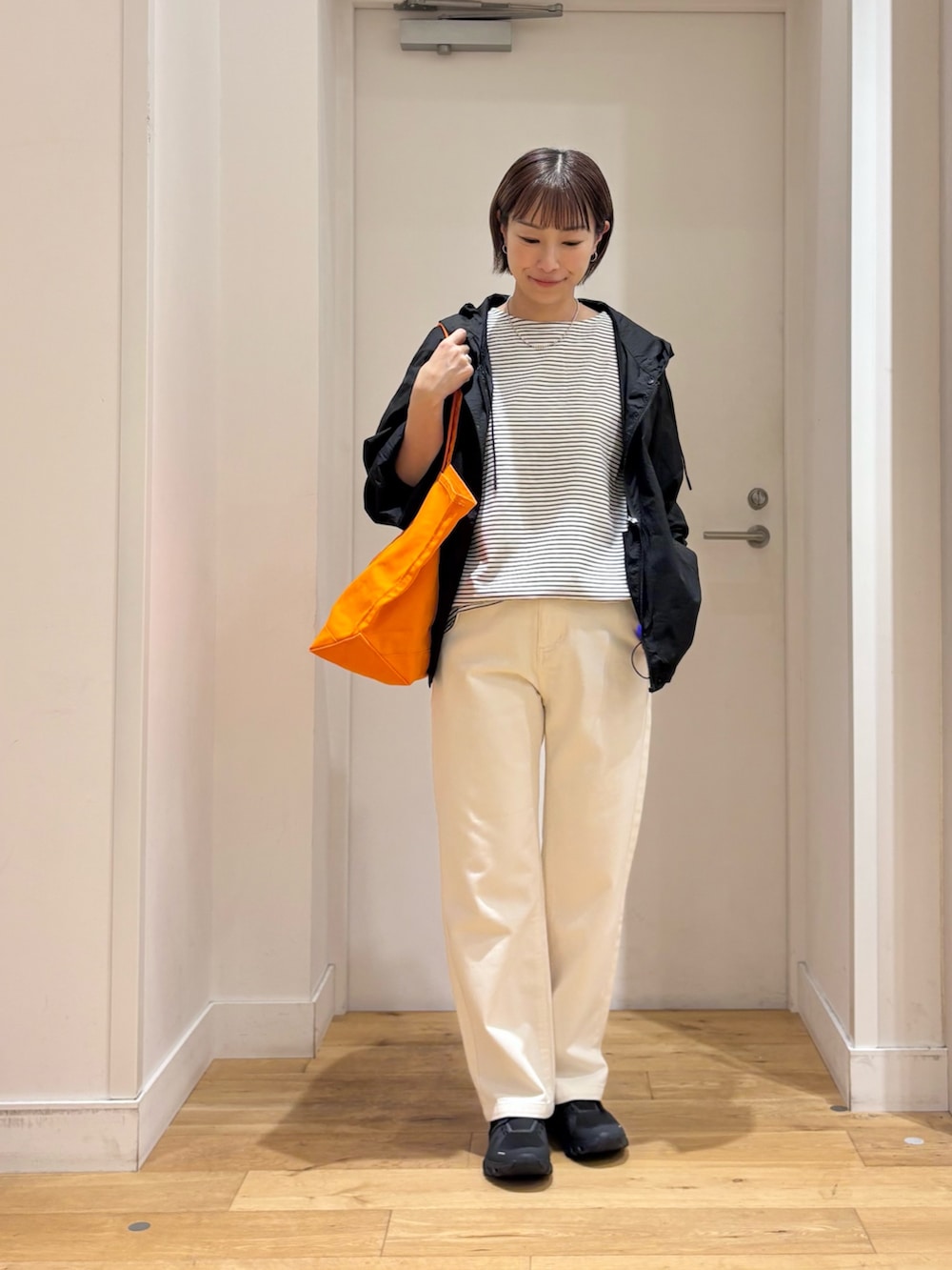 ホワイト系のTシャツ/カットソー、ブラック系のナイロンジャケット、ベージュ系のその他パンツを着用したレディースの夏コーディネートの2枚目の写真