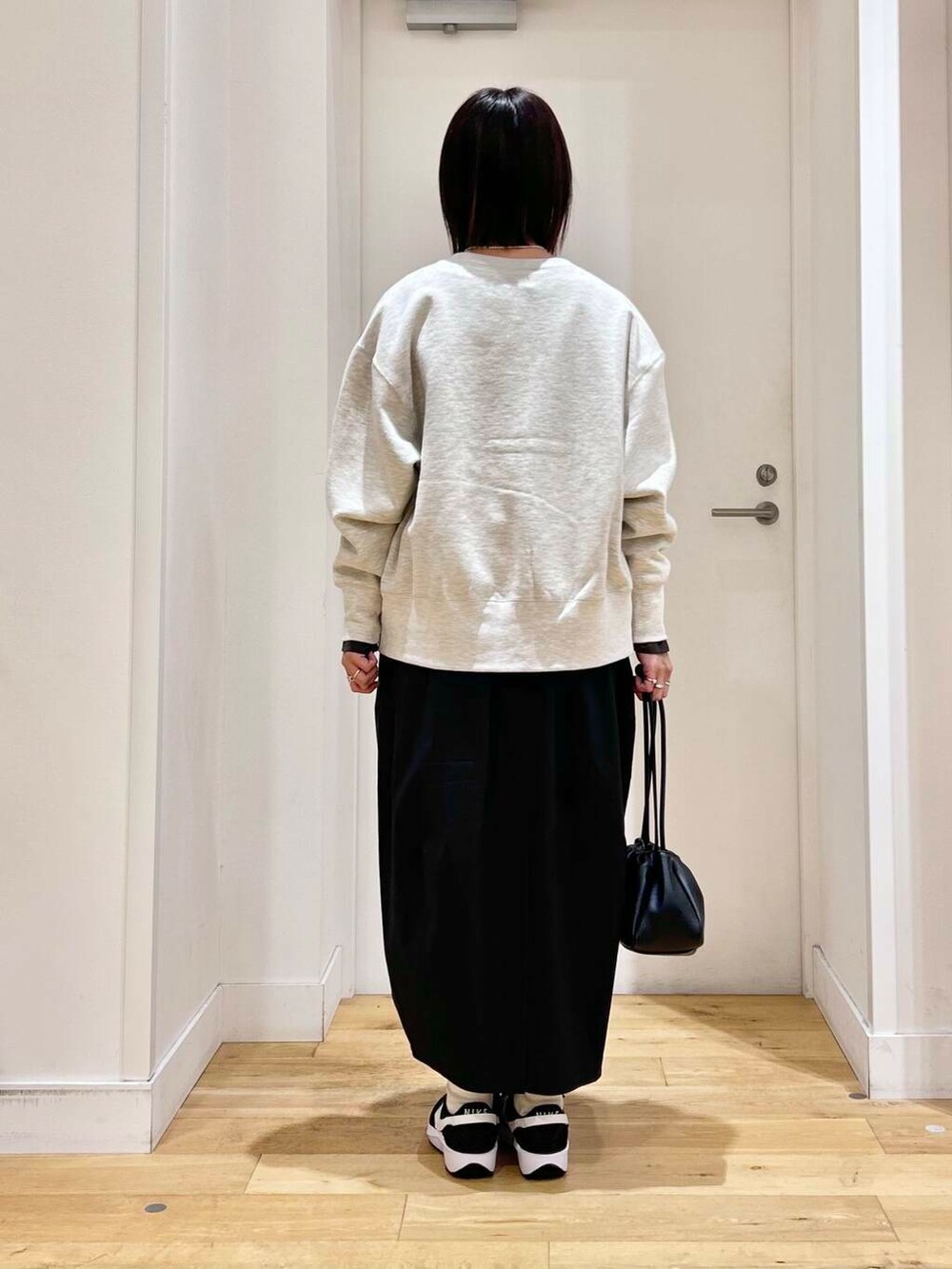 グレー系のTシャツ/カットソー、ブラック系のショルダーバッグ、ベージュ系のカーディガン/ボレロを着用したレディースの冬コーディネートの5枚目の写真