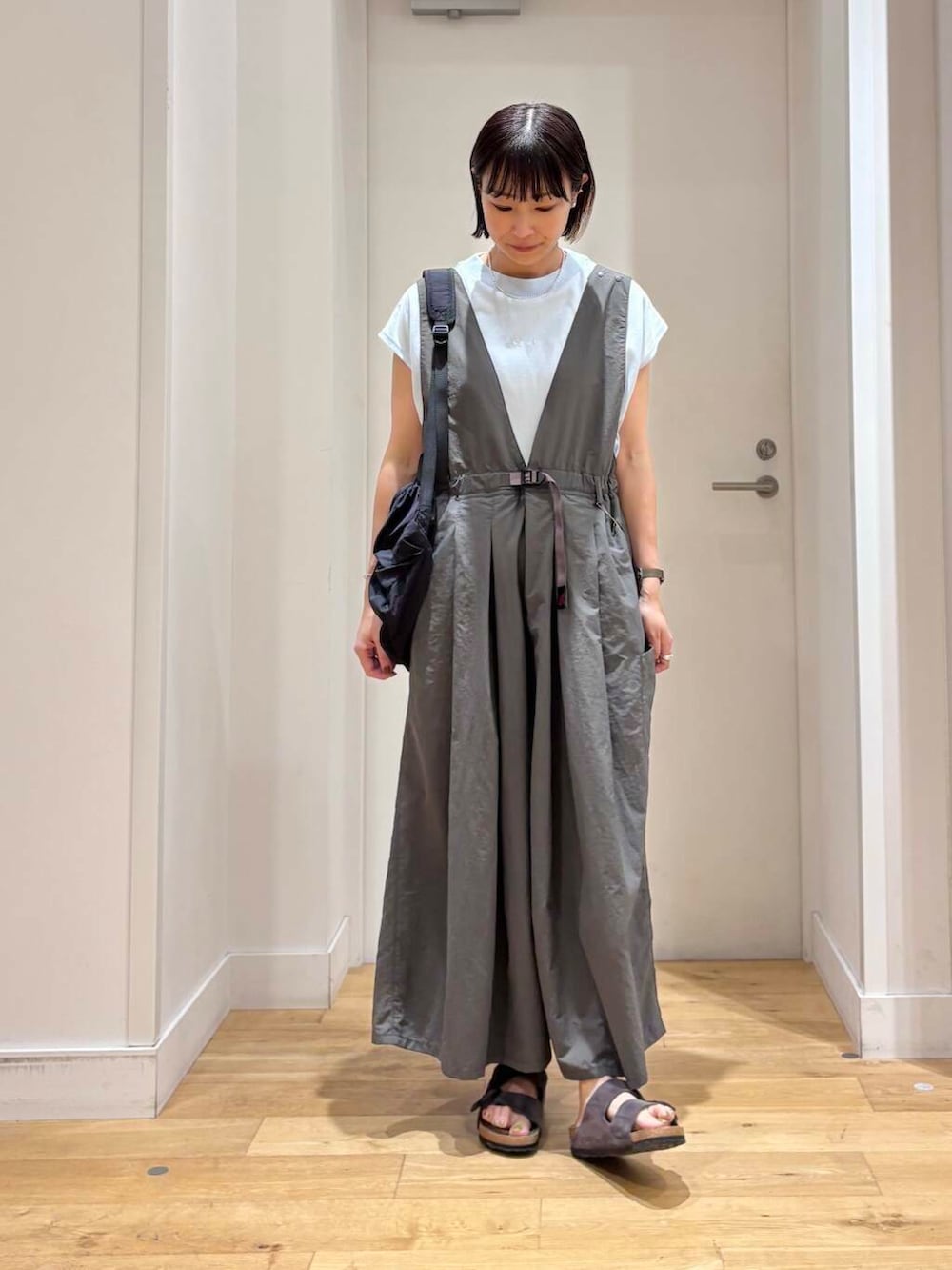 グレー系のサロペット/オーバーオール、ブラック系のバックパック/リュック、ブルー系のTシャツ/カットソーを着用したレディースの夏コーディネートの4枚目の写真