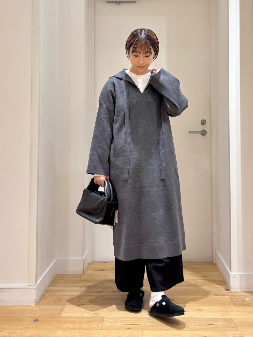 グレー系のワンピース、ホワイト系のシャツ/ブラウス、ブラック系のその他パンツを着用したレディースの秋コーディネートの2枚目の写真