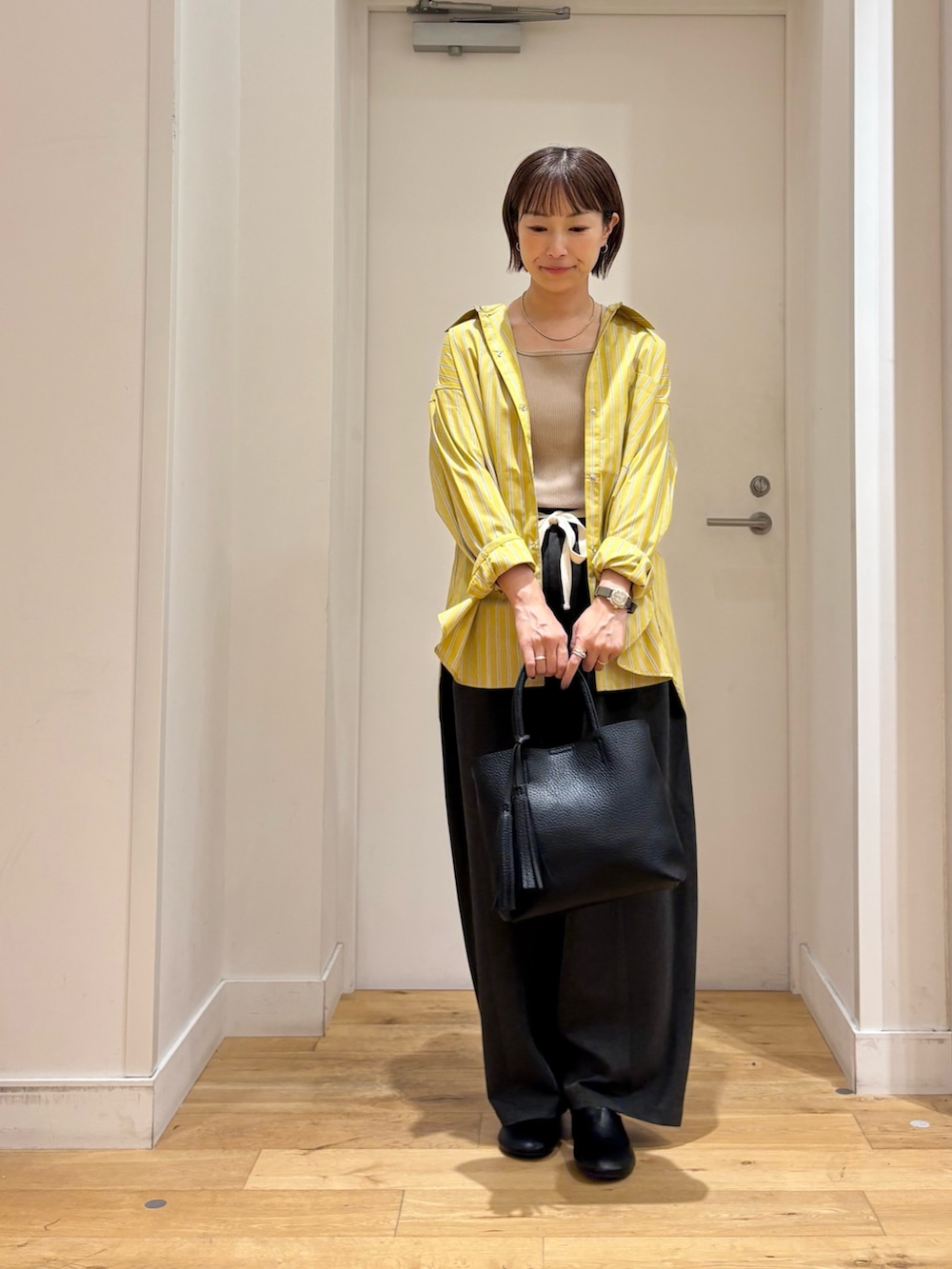 イエロー系のシャツ/ブラウス、グレー系のその他パンツ、ベージュ系のタンクトップを着用したレディースの夏コーディネートの3枚目の写真