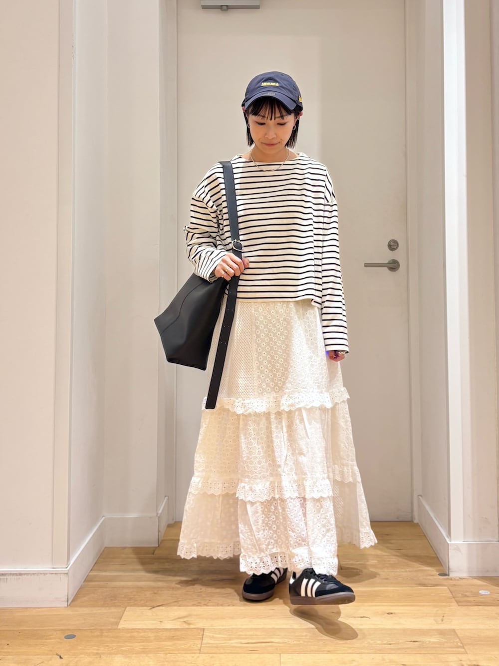 ホワイト系のTシャツ/カットソー、ホワイト系のスカート、ブラック系のショルダーバッグを着用したレディースの秋コーディネートの3枚目の写真