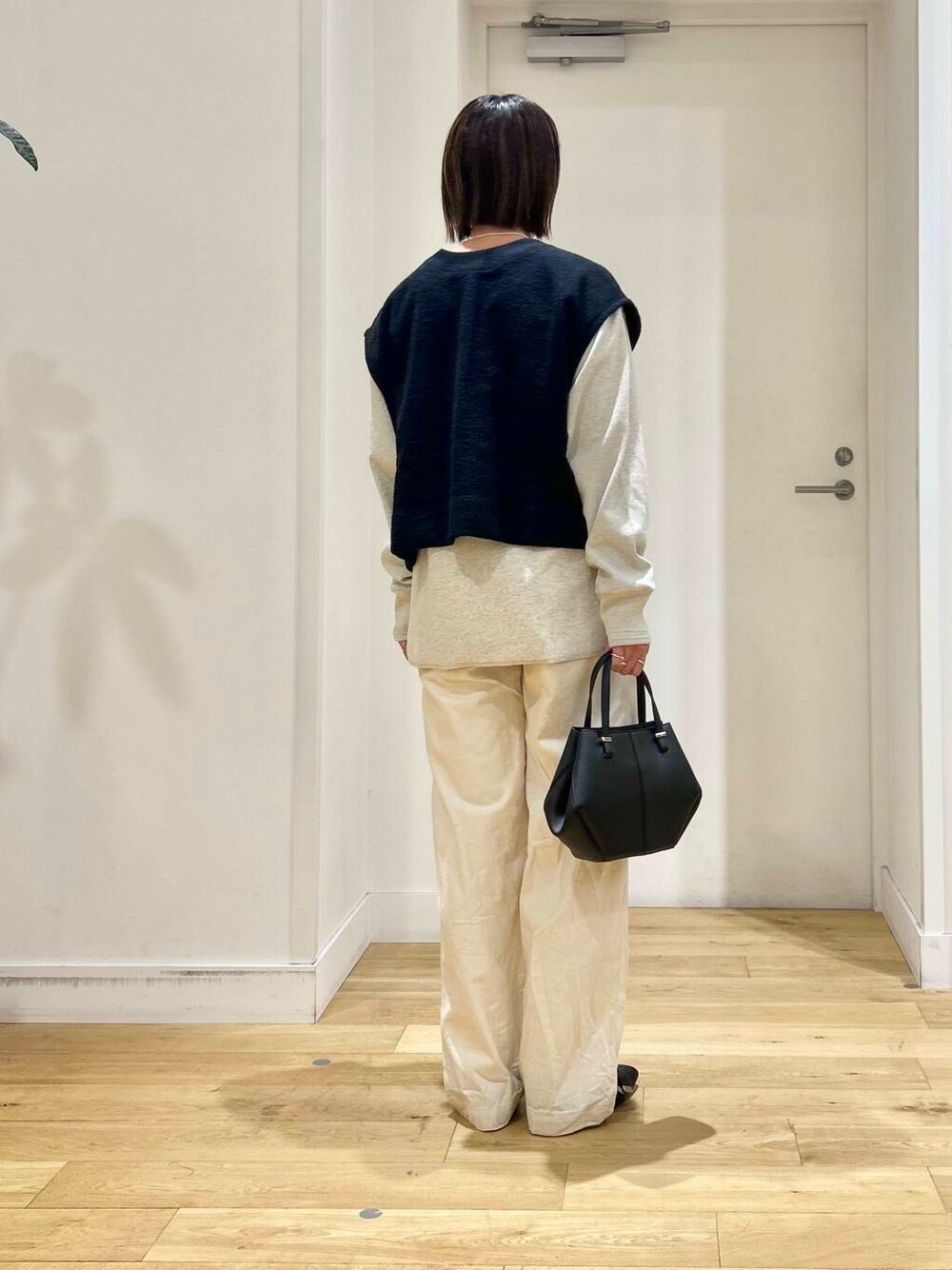 ブラック系のドレスシューズ、ベージュ系のデニムパンツ、ブラック系のショルダーバッグを着用したレディースの冬コーディネートの6枚目の写真