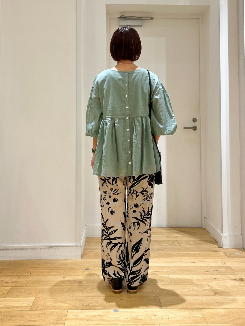 グリーン系のシャツ/ブラウス、ベージュ系のその他パンツ、ブラック系のサンダルを着用したレディースの春コーディネートの3枚目の写真