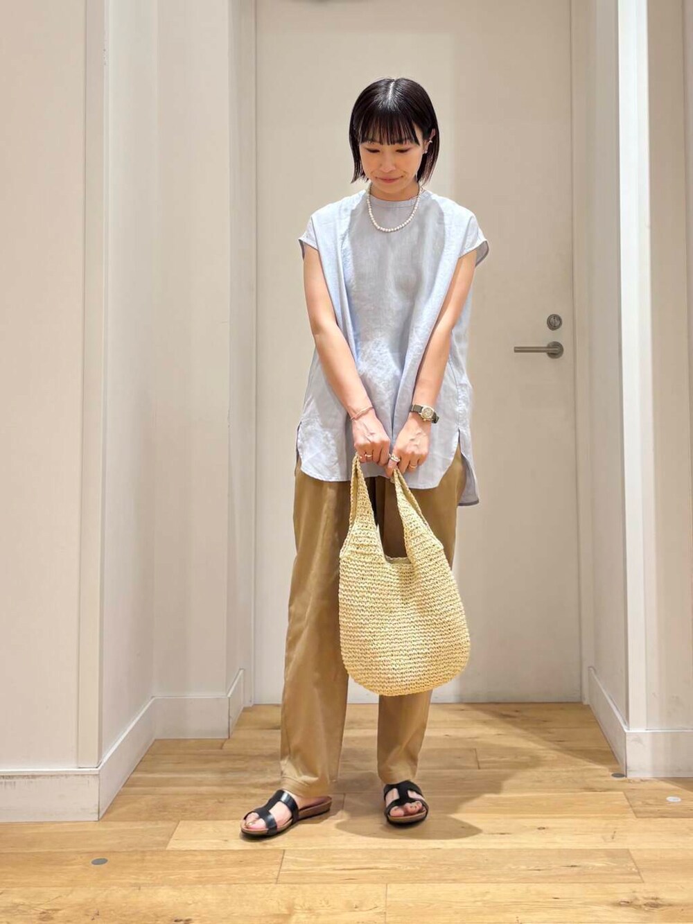 ベージュ系のトートバッグ、ベージュ系のその他パンツ、ブルー系のシャツ/ブラウスを着用したレディースの夏コーディネートの3枚目の写真