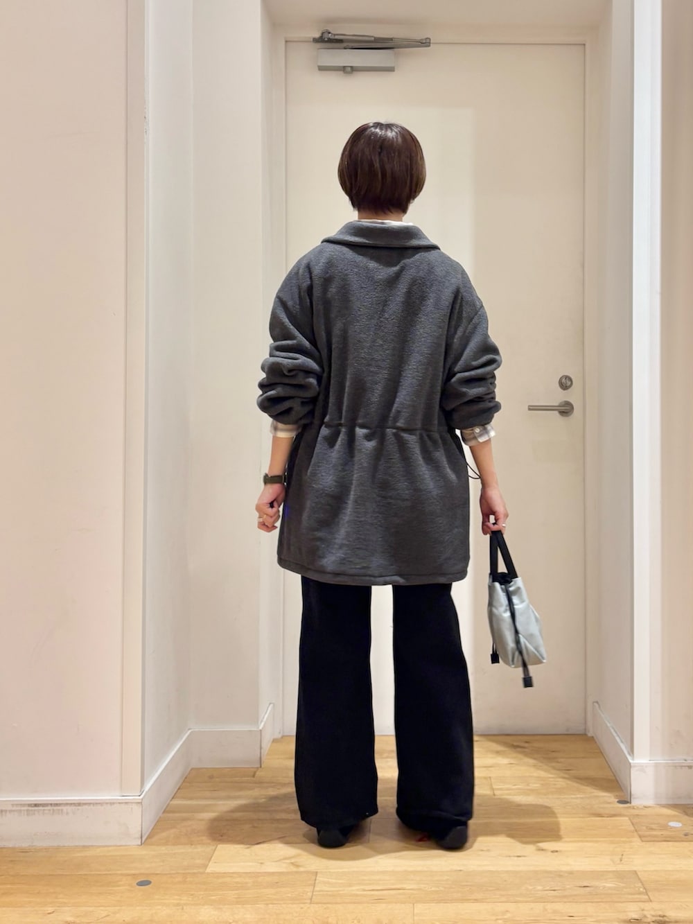 グレー系のスウェット、ブラック系のデニムパンツ、ホワイト系のシャツ/ブラウスを着用したレディースの秋コーディネートの6枚目の写真