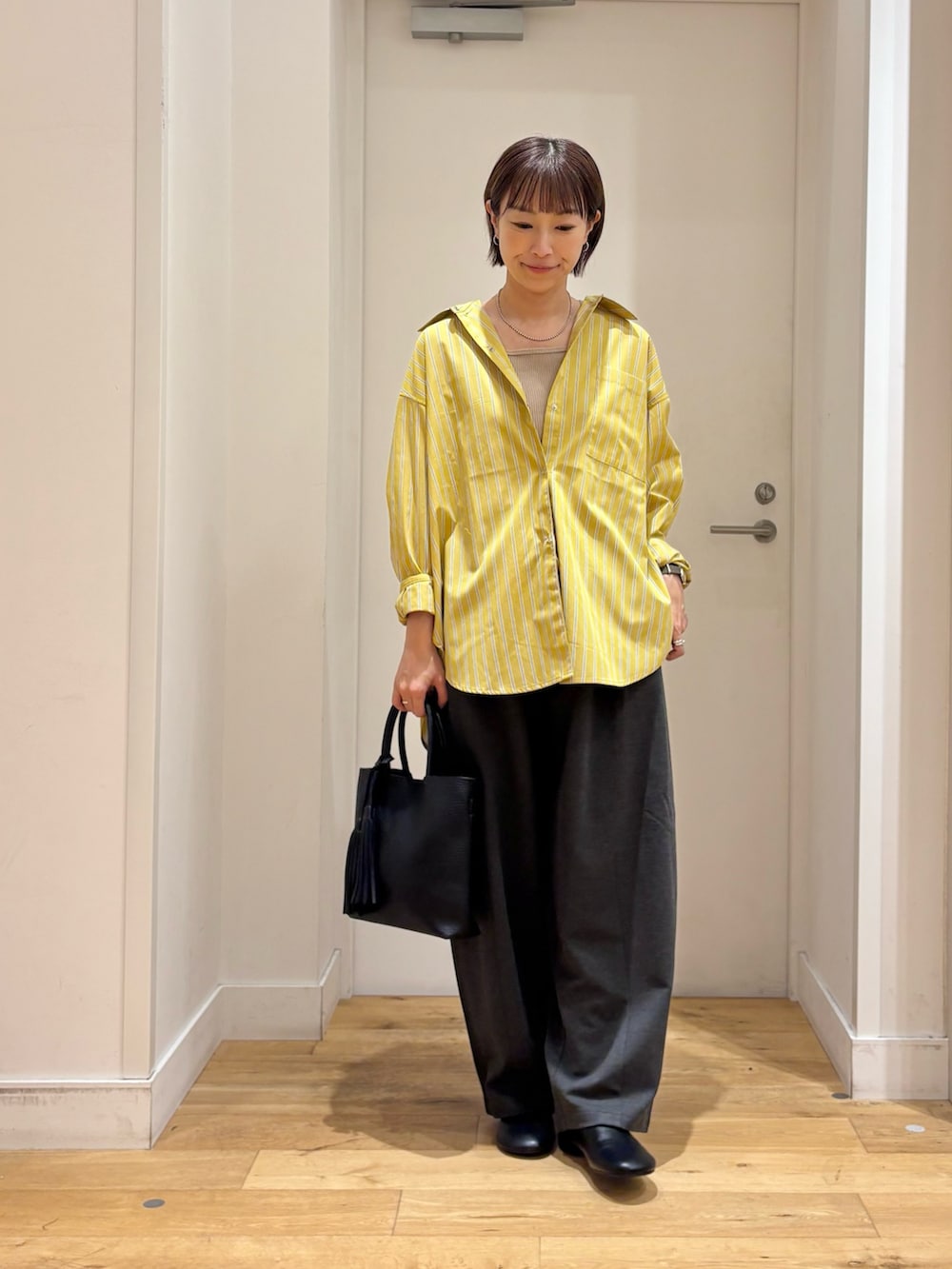 イエロー系のシャツ/ブラウス、グレー系のその他パンツ、ベージュ系のタンクトップを着用したレディースの夏コーディネートの4枚目の写真