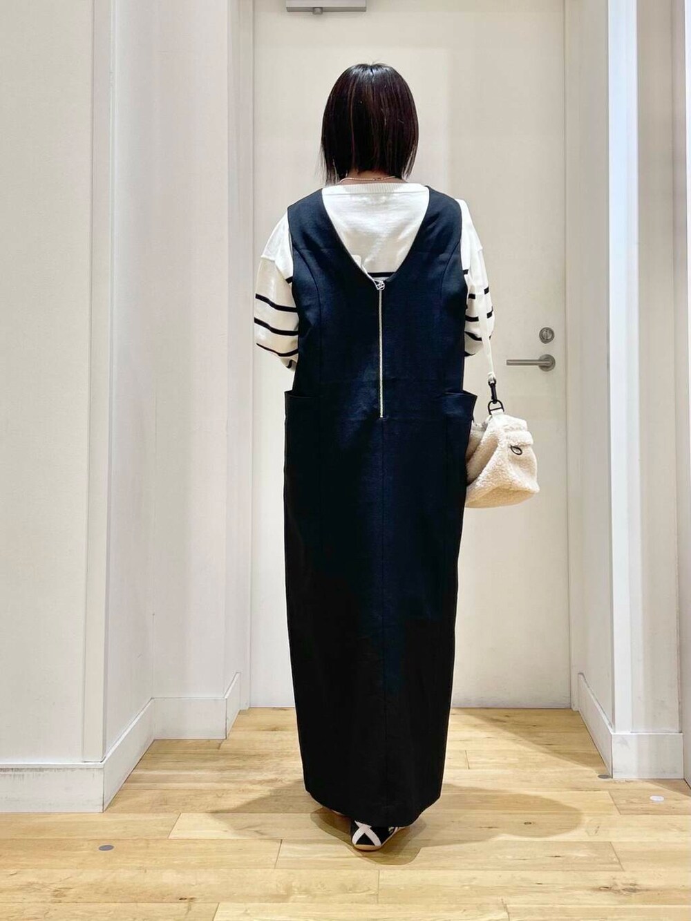 ブラック系のニット/セーター、ブラック系のワンピース、ブラック系のカーディガン/ボレロを着用したレディースの冬コーディネートの5枚目の写真