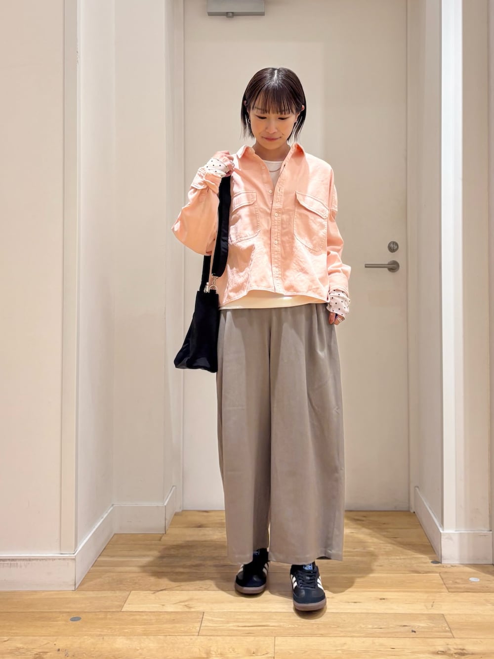 ピンク系のシャツ/ブラウス、ホワイト系のTシャツ/カットソー、ブラック系のスニーカーを着用したレディースの冬コーディネートの2枚目の写真