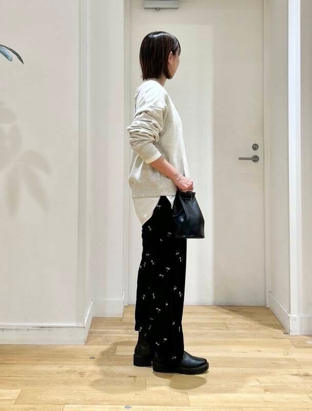 ベージュ系のスウェット、ブラック系のショルダーバッグ、ホワイト系のTシャツ/カットソーを着用したレディースの秋コーディネートの4枚目の写真