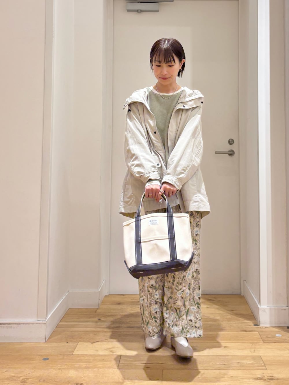 ベージュ系のマウンテンパーカー、グリーン系のニット/セーター、グレー系のパンプスを着用したレディースの春コーディネートの4枚目の写真