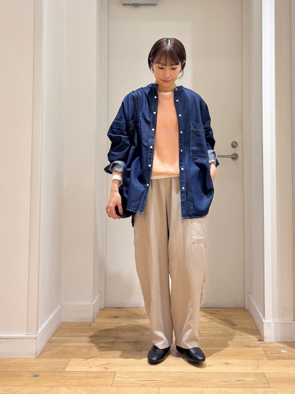 ブルー系のシャツ/ブラウス、ピンク系のニット/セーター、ホワイト系のTシャツ/カットソーを着用したレディースの春コーディネートの2枚目の写真