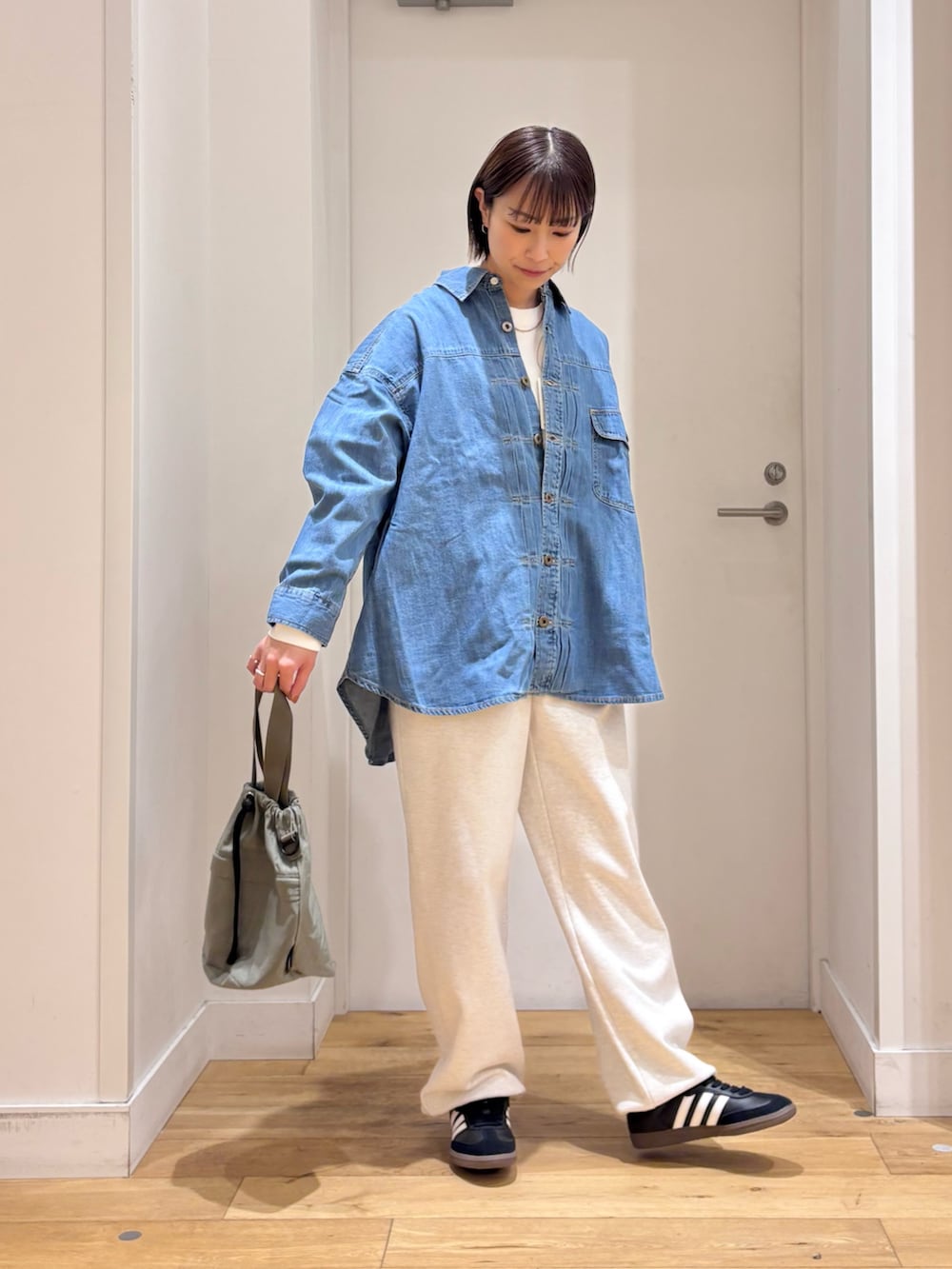 グレー系のその他パンツ、ブルー系のショルダーバッグ、ブラック系のスニーカーを着用したレディースの冬コーディネートの6枚目の写真