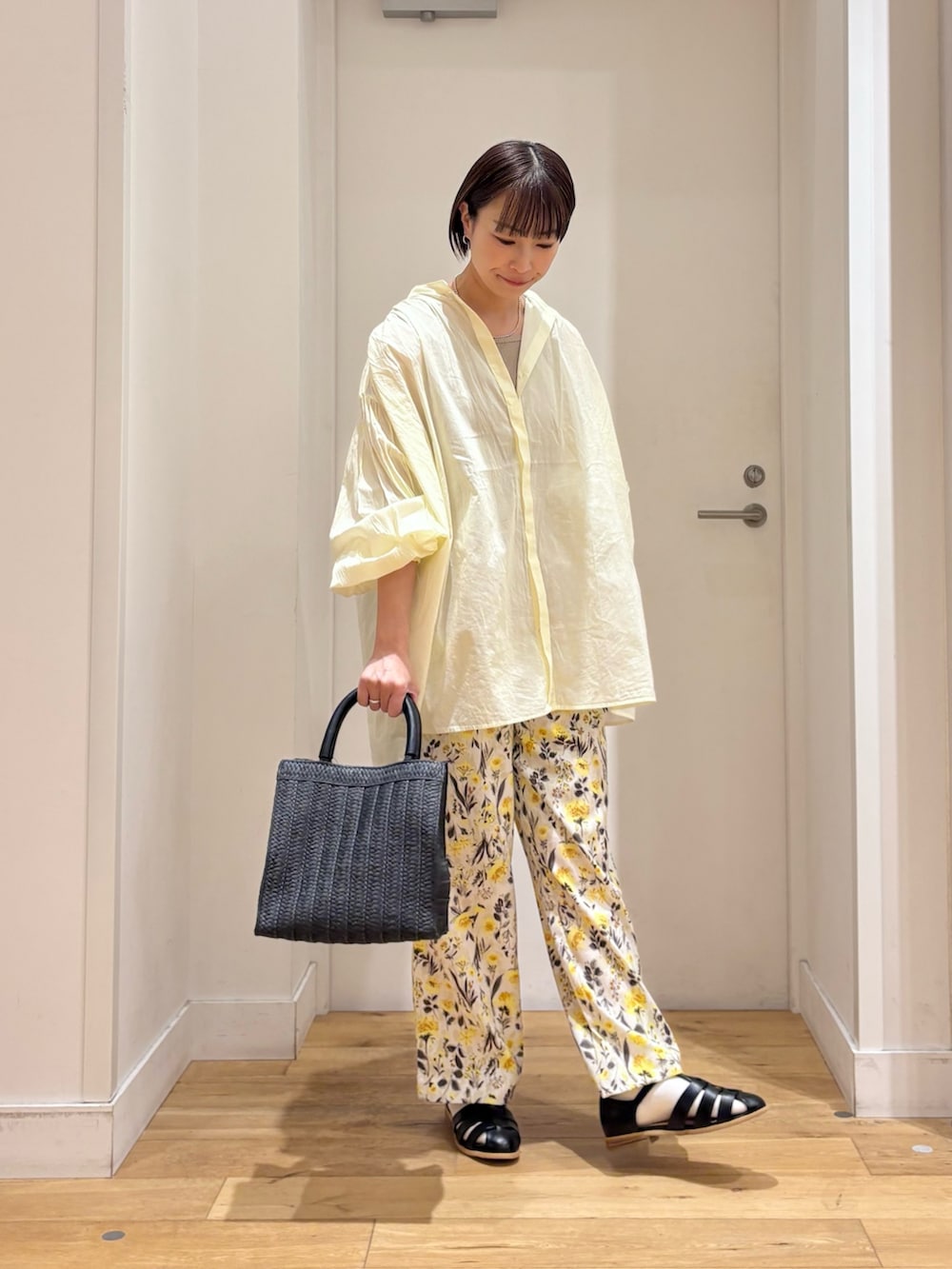 ベージュ系のタンクトップ、イエロー系のシャツ/ブラウス、ブラック系のサンダルを着用したレディースの春コーディネートの5枚目の写真