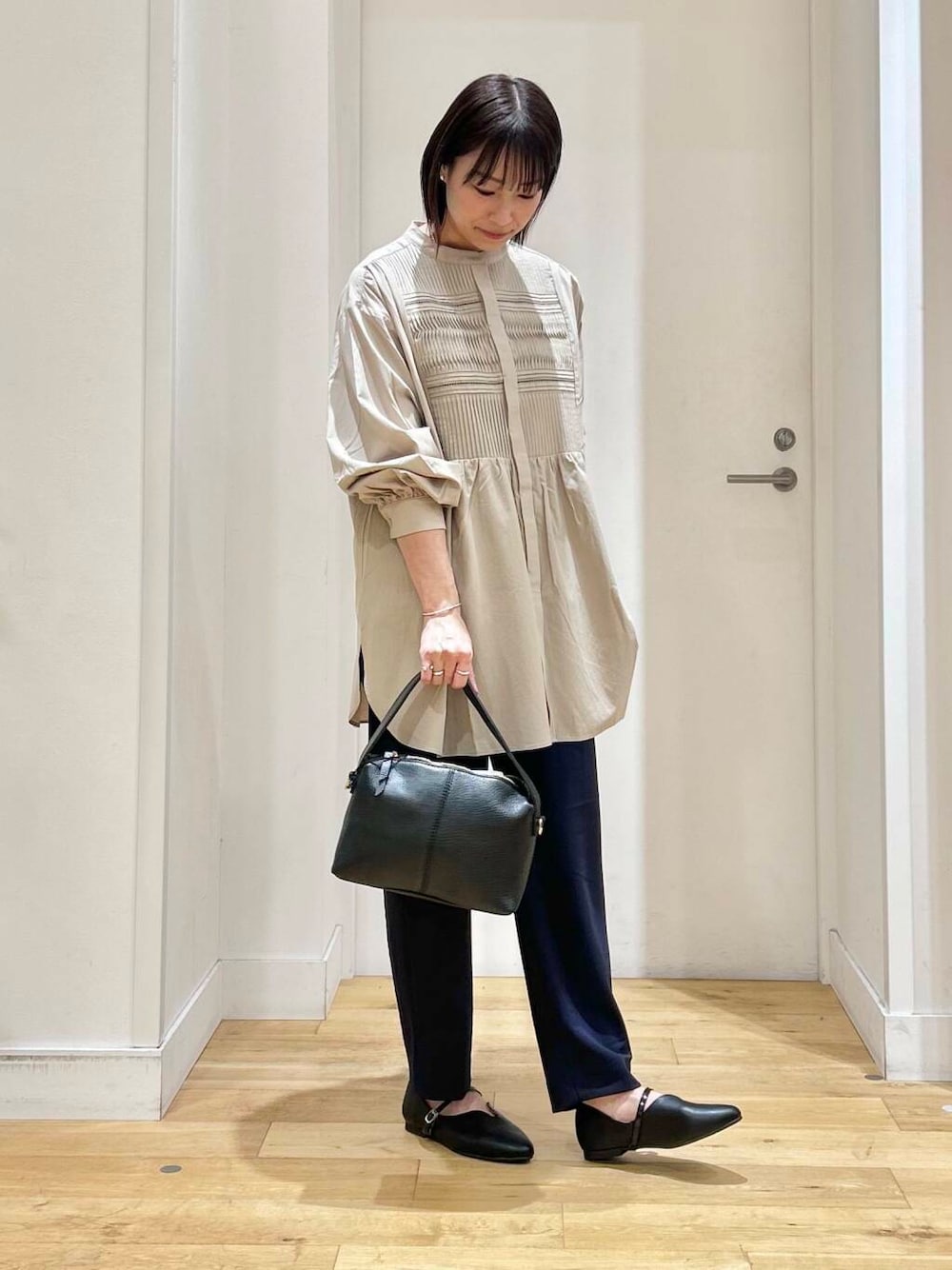 ベージュ系のシャツ/ブラウス、ブルー系のその他パンツ、ブラック系のパンプスを着用したレディースの冬コーディネートの3枚目の写真