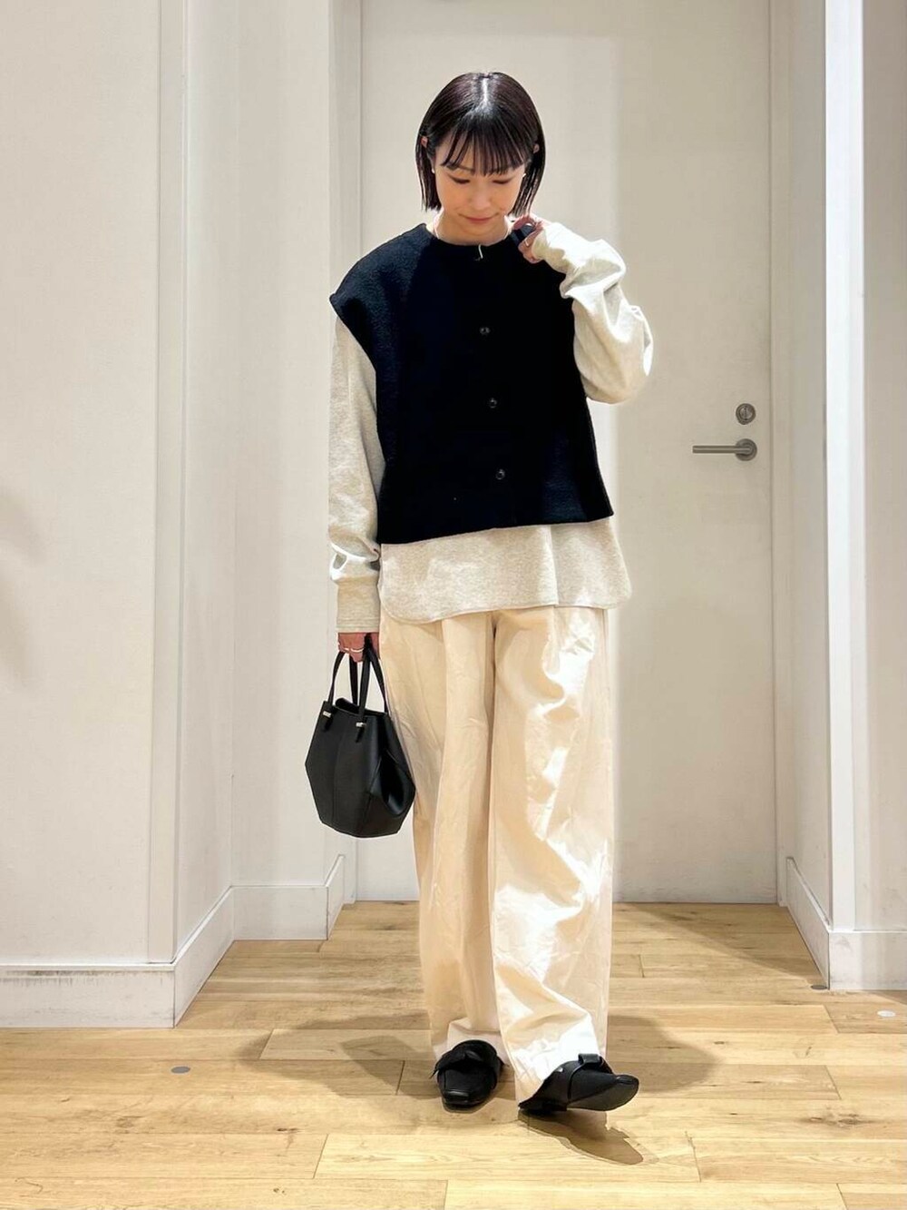 ブラック系のドレスシューズ、ベージュ系のデニムパンツ、ブラック系のショルダーバッグを着用したレディースの冬コーディネートの4枚目の写真