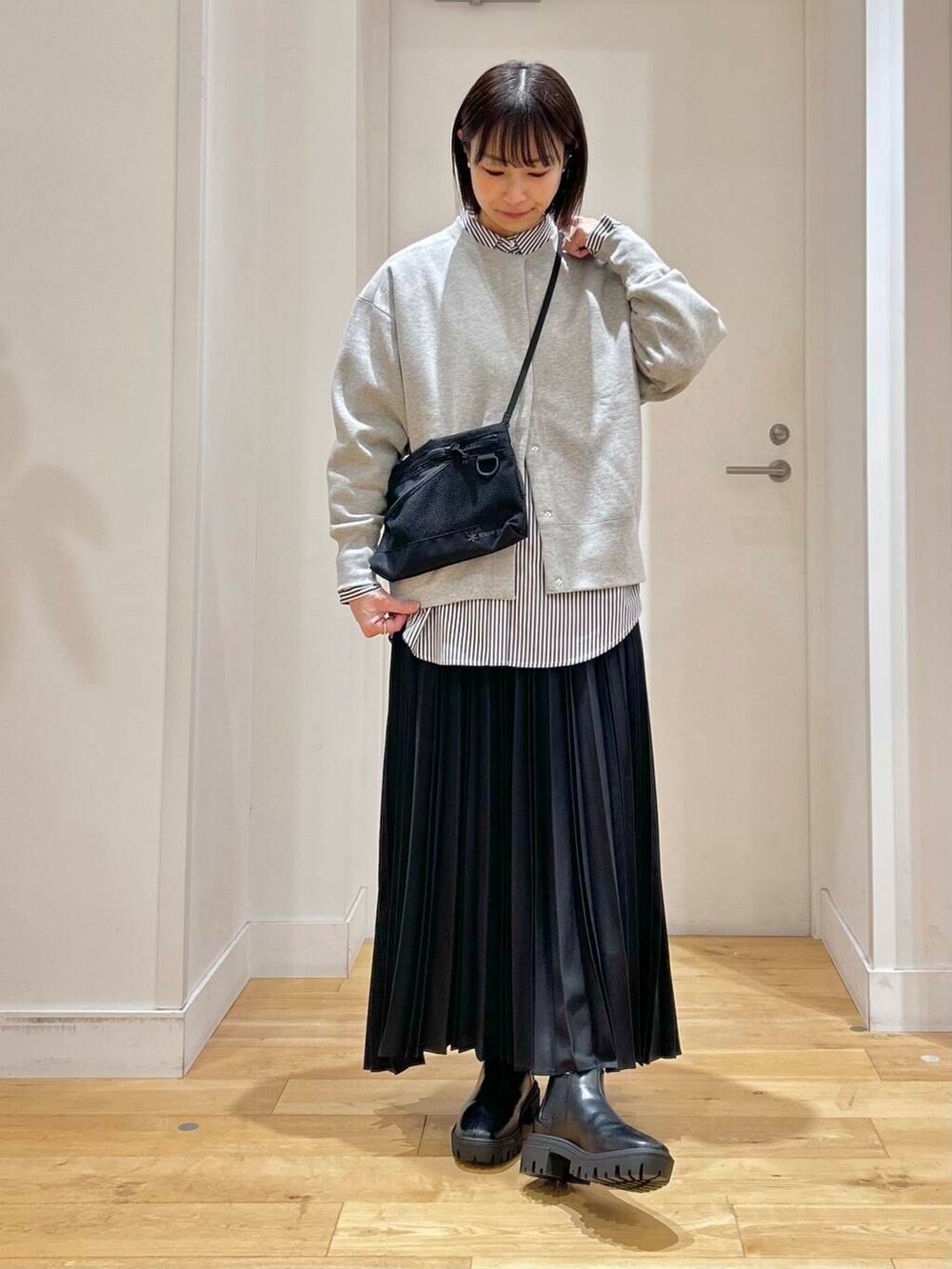 ブルー系のシャツ/ブラウス、ブラック系のブーツ、ブラック系のショルダーバッグを着用したレディースの冬コーディネートの2枚目の写真