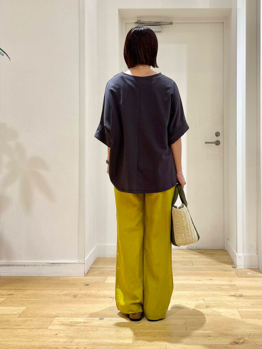 ベージュ系のかごバッグ、イエロー系のその他パンツ、ブラック系のサンダルを着用したレディースの夏コーディネートの5枚目の写真