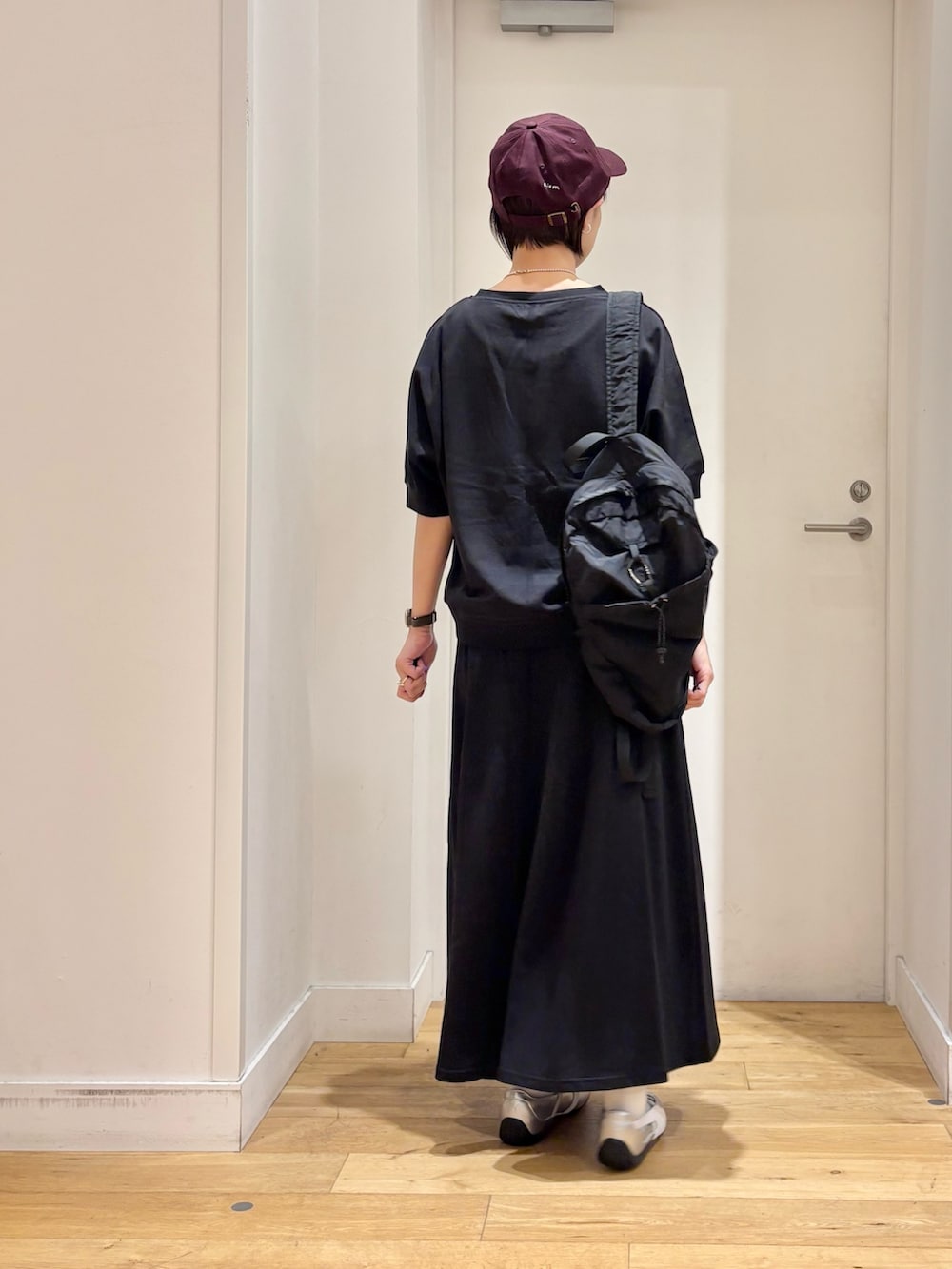 ブラック系のTシャツ/カットソー、ブラック系のバックパック/リュック、シルバー系のスニーカーを着用したレディースの春コーディネートの5枚目の写真