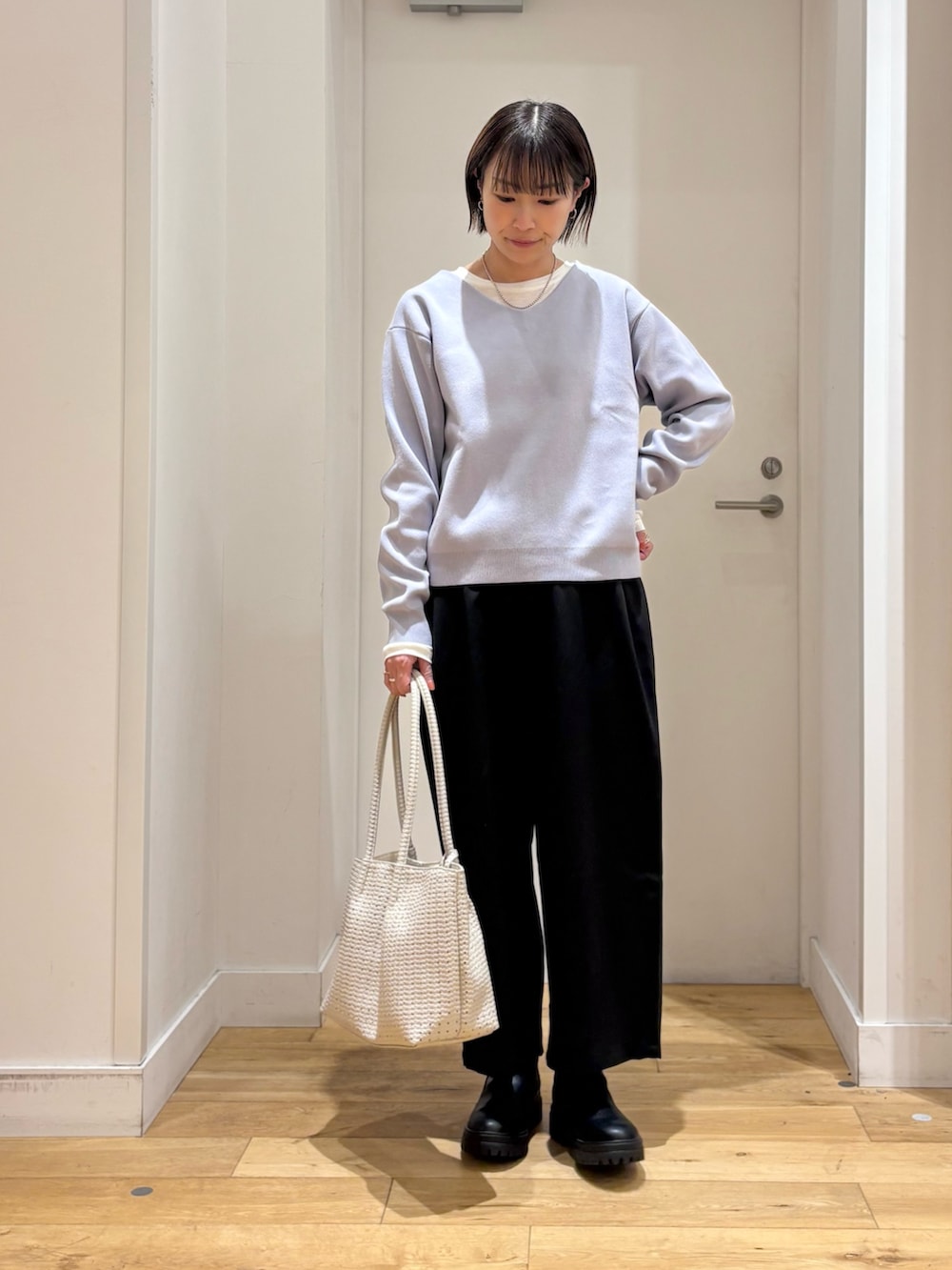 ブラック系のその他パンツ、ホワイト系のトートバッグ、ブラック系のブーツを着用したレディースの冬コーディネートの3枚目の写真