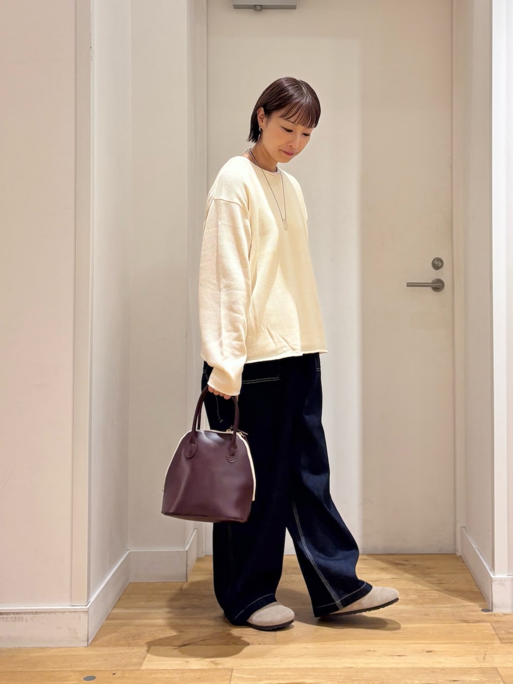 ホワイト系のニット/セーター、ブルー系のデニムパンツ、ベージュ系のその他シューズを着用したレディースの秋コーディネートの6枚目の写真