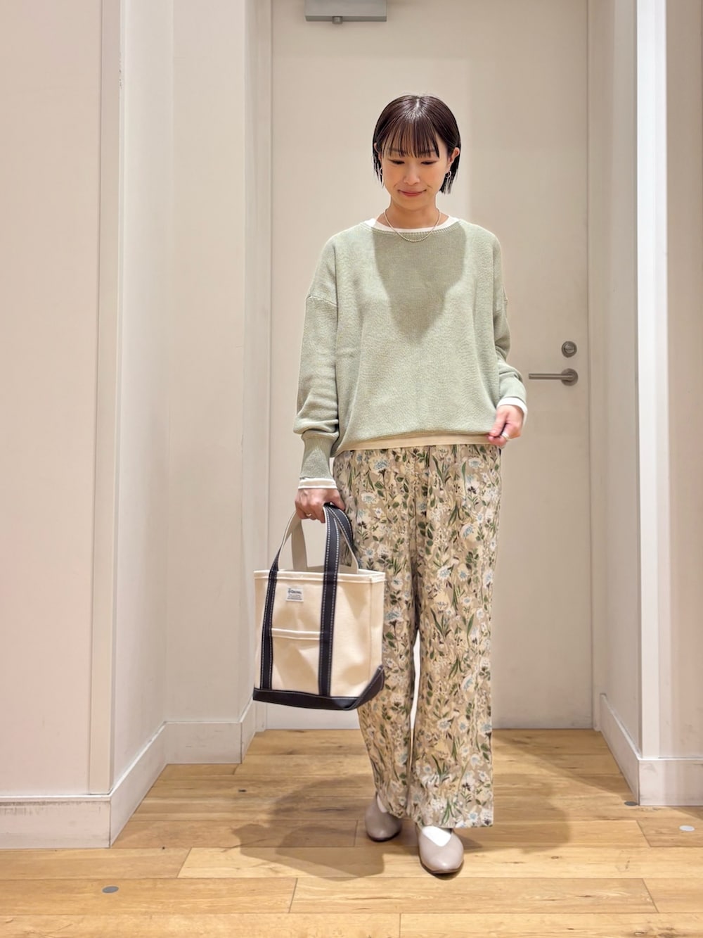 ベージュ系のマウンテンパーカー、グリーン系のニット/セーター、グレー系のパンプスを着用したレディースの春コーディネートの7枚目の写真