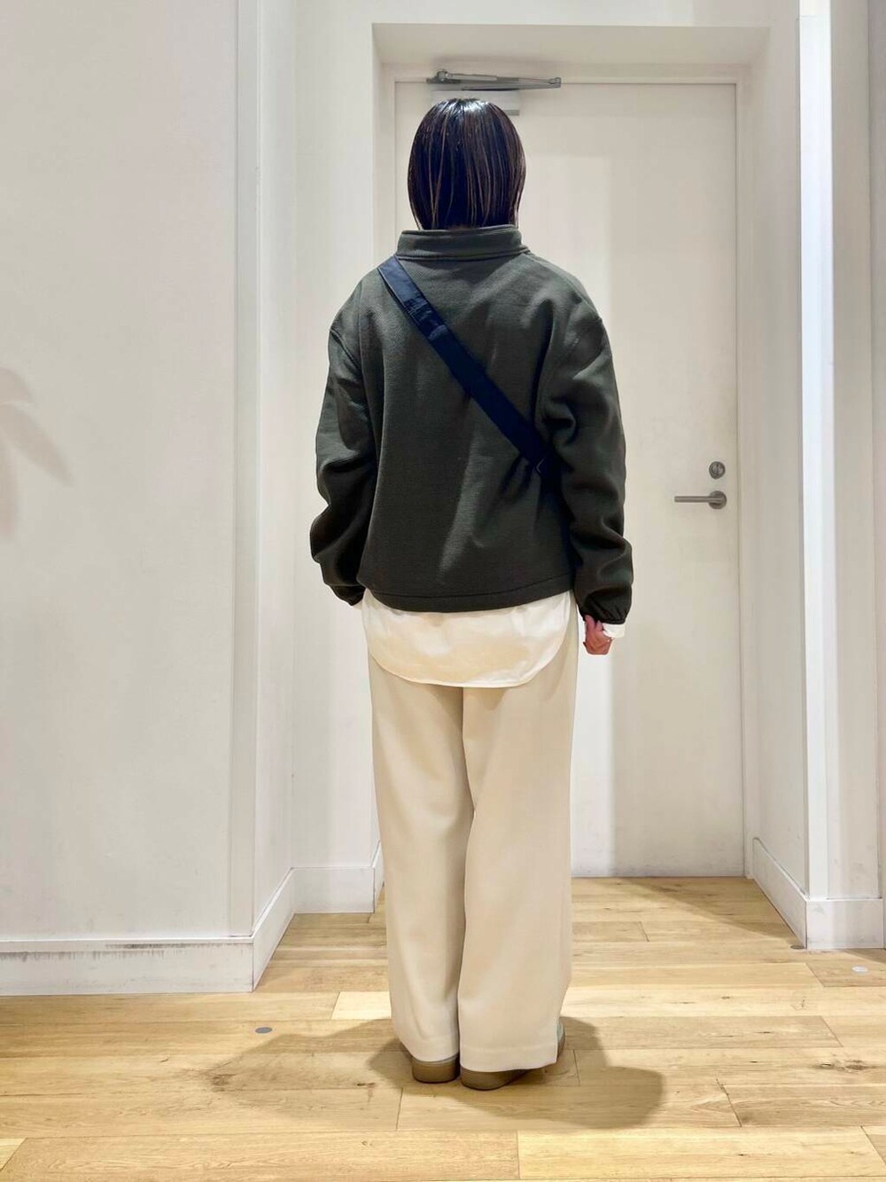 ブラック系のショルダーバッグ、ホワイト系のその他パンツ、ホワイト系のTシャツ/カットソーを着用したレディースの冬コーディネートの3枚目の写真