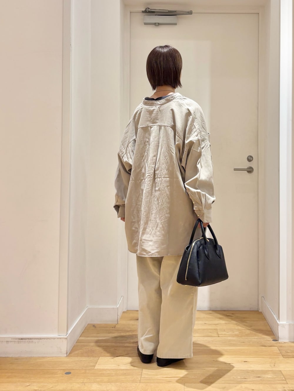 グレー系のTシャツ/カットソー、ホワイト系のその他パンツ、ブラック系のハンドバッグを着用したレディースの秋コーディネートの5枚目の写真