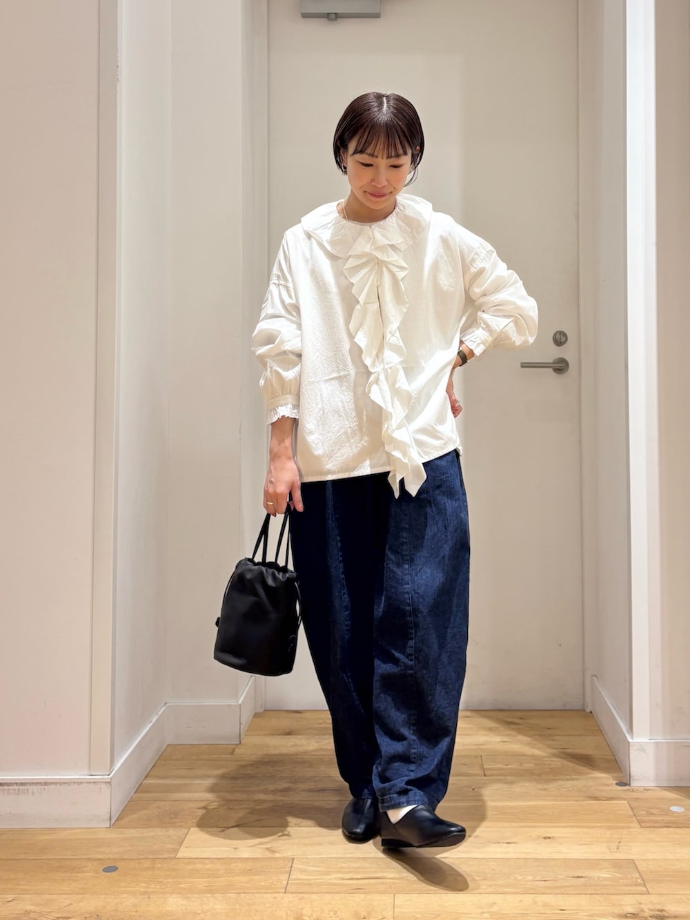 ブルー系のデニムパンツ、ブラック系のその他シューズ、ホワイト系のシャツ/ブラウスを着用したレディースの冬コーディネートの2枚目の写真