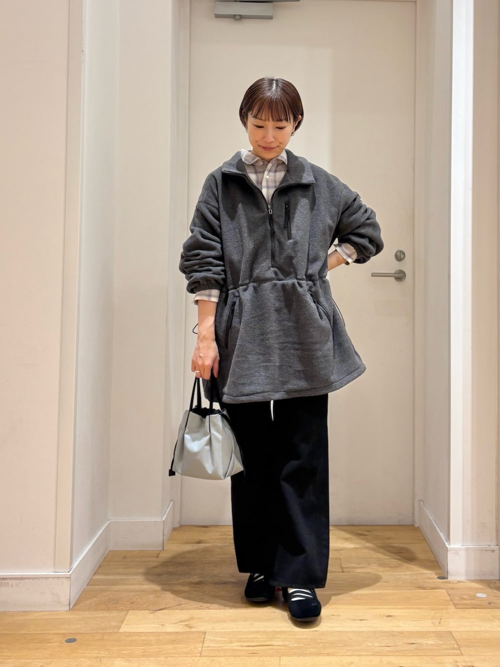 グレー系のスウェット、ブラック系のデニムパンツ、ホワイト系のシャツ/ブラウスを着用したレディースの秋コーディネートの3枚目の写真