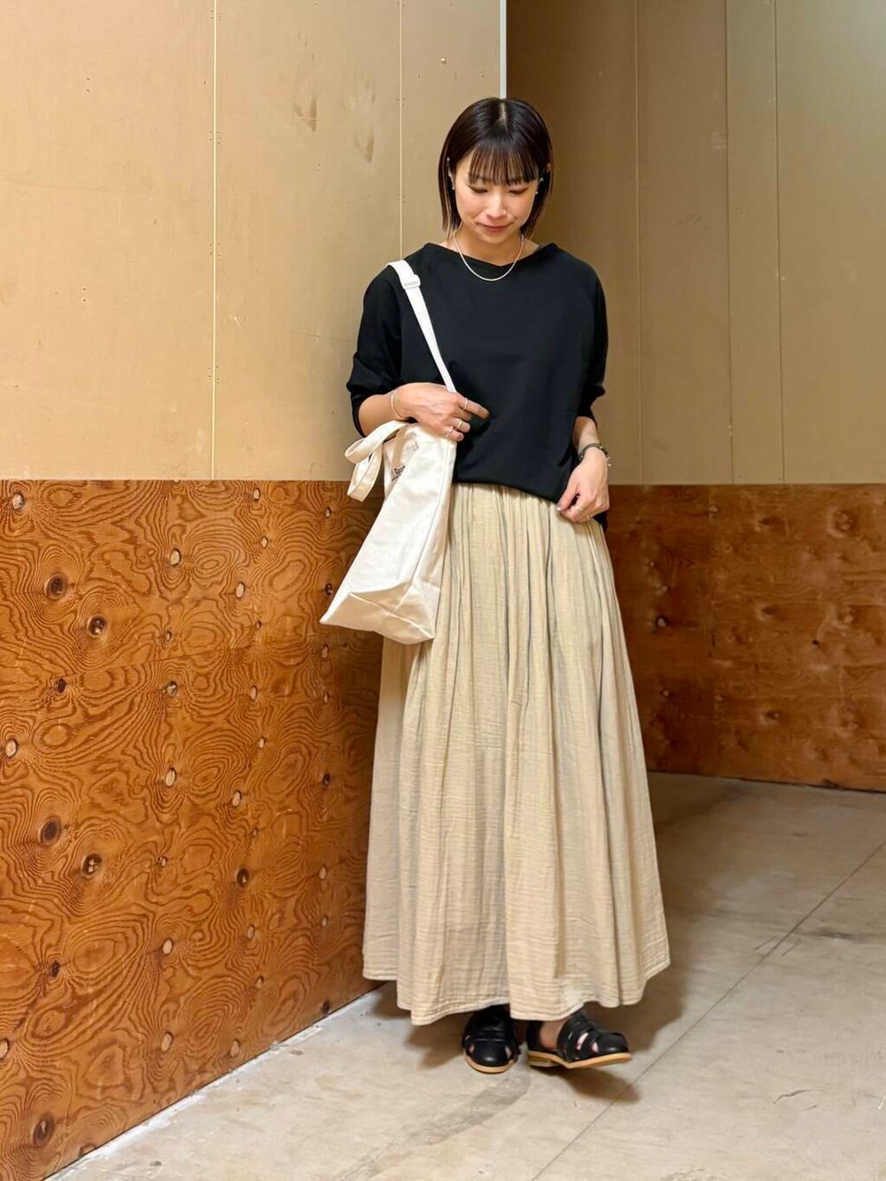 ブラック系のサンダル、ベージュ系のスカート、ブラック系のTシャツ/カットソーを着用したレディースの春コーディネートの4枚目の写真