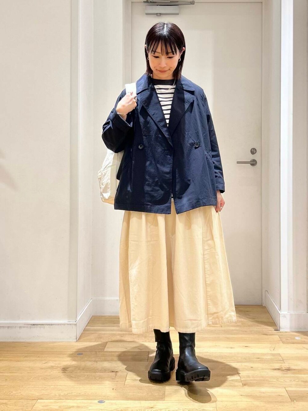 ホワイト系のバックパック/リュック、ホワイト系のTシャツ/カットソー、ブラック系のブーツを着用したレディースの秋コーディネートの2枚目の写真