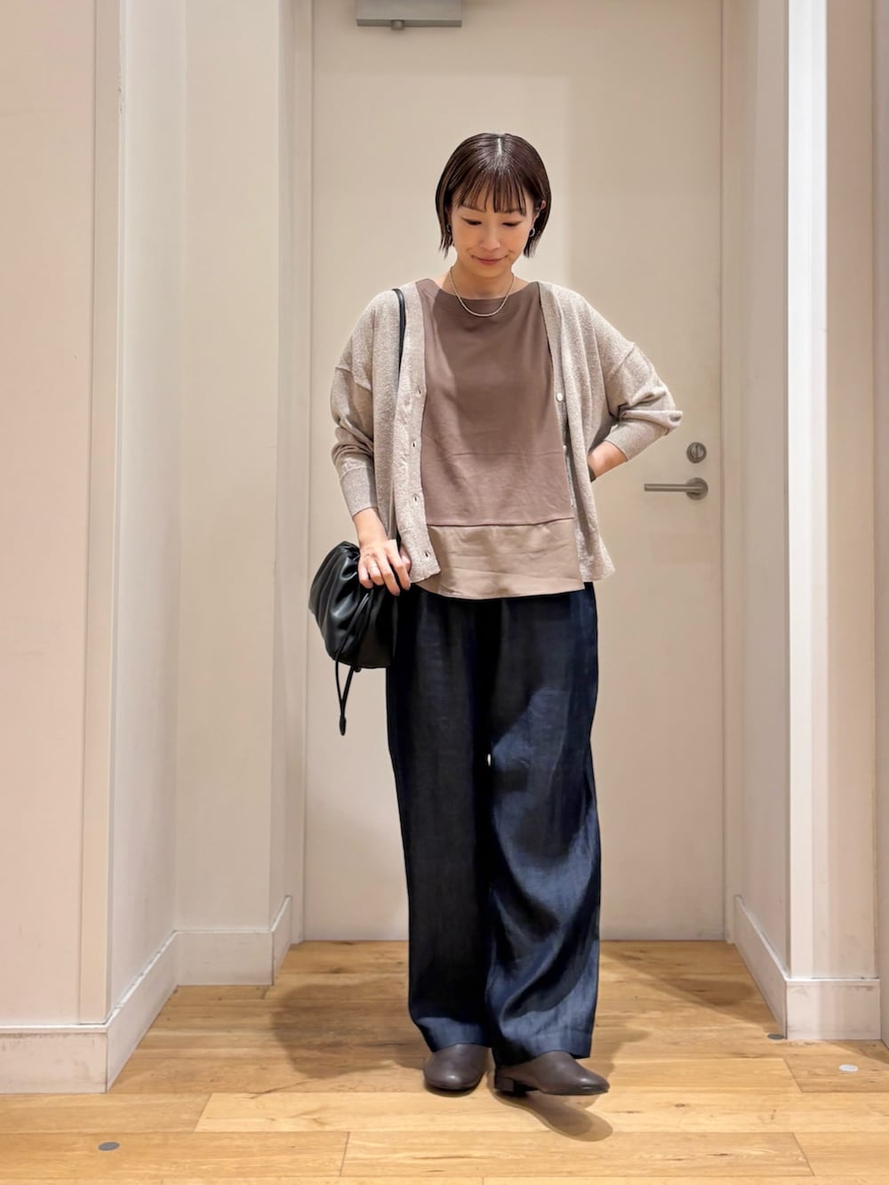 ブラウン系のTシャツ/カットソー、ブルー系のデニムパンツ、ベージュ系のカーディガン/ボレロを着用したレディースの夏コーディネートの2枚目の写真