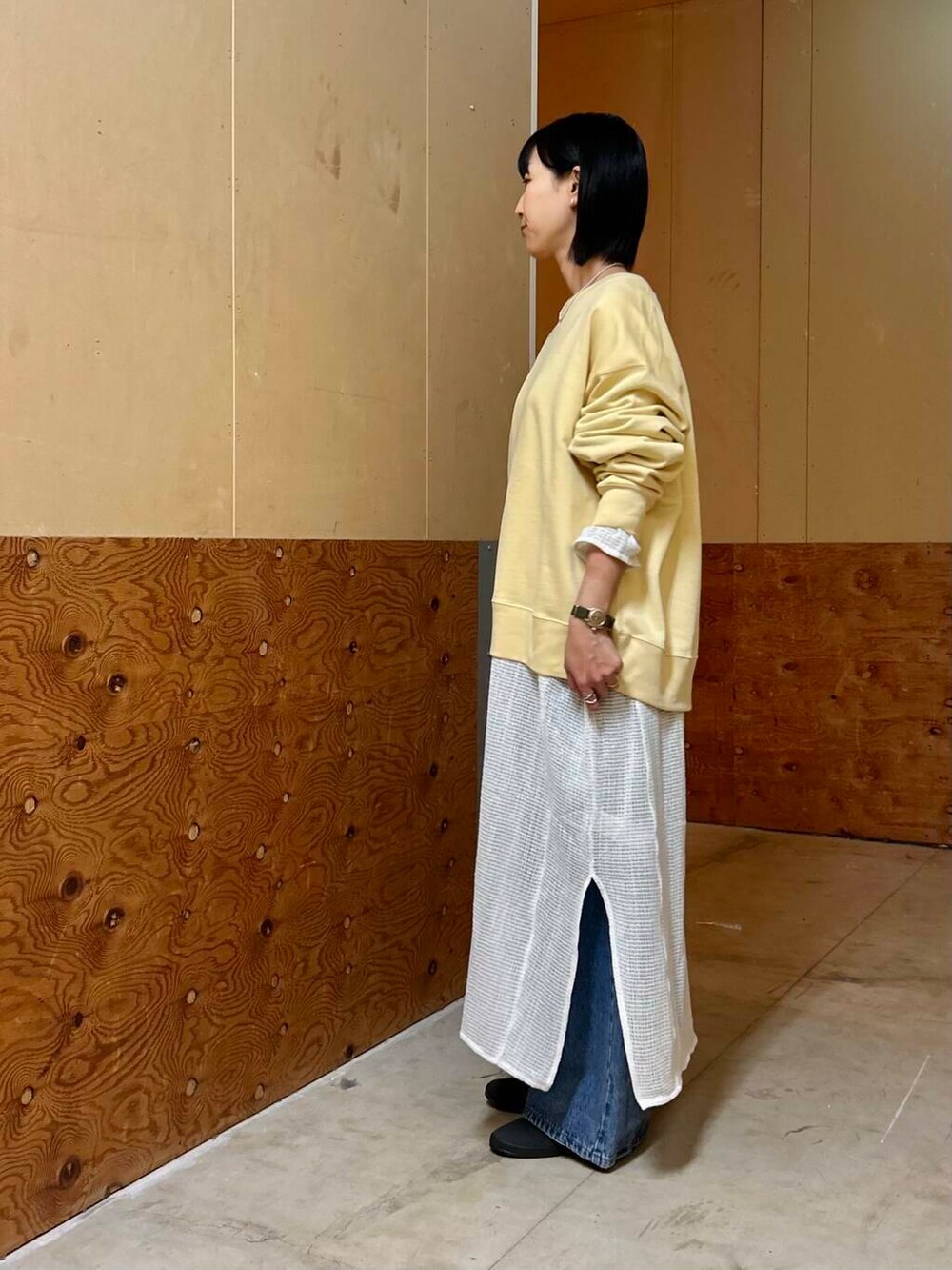 イエロー系のボストンバッグ、イエロー系のスウェット、ホワイト系のワンピースを着用したレディースの春コーディネートの5枚目の写真