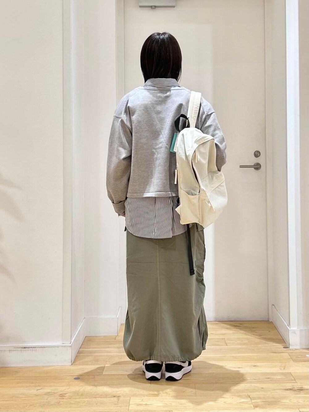 ブルー系のシャツ/ブラウス、グリーン系のスカート、ホワイト系のバックパック/リュックを着用したレディースの冬コーディネートの5枚目の写真