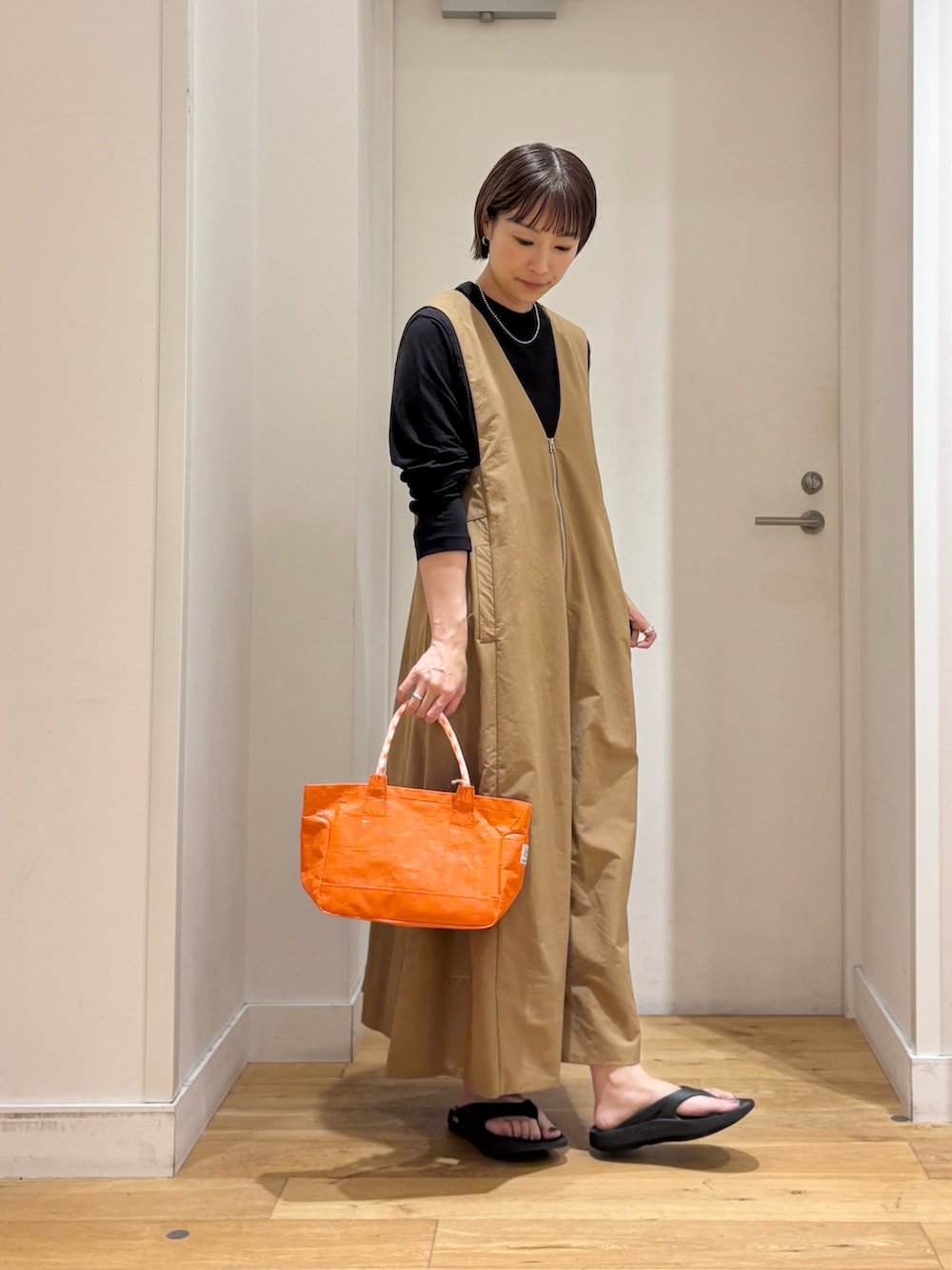 ブラック系のTシャツ/カットソー、ベージュ系のワンピース、オレンジ系のショルダーバッグを着用したレディースの夏コーディネートの5枚目の写真