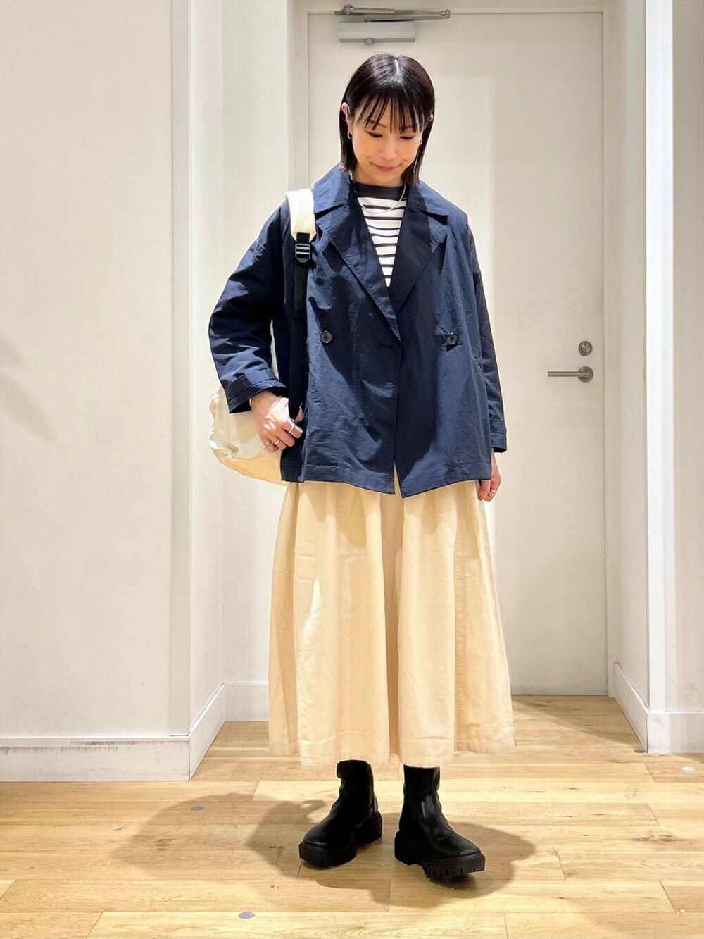 ホワイト系のバックパック/リュック、ホワイト系のTシャツ/カットソー、ブラック系のブーツを着用したレディースの秋コーディネートの3枚目の写真