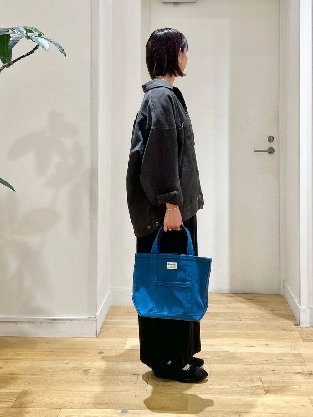 ホワイト系のTシャツ/カットソー、ブラック系のバレエシューズ、グレー系のブルゾンを着用したレディースの秋コーディネートの4枚目の写真