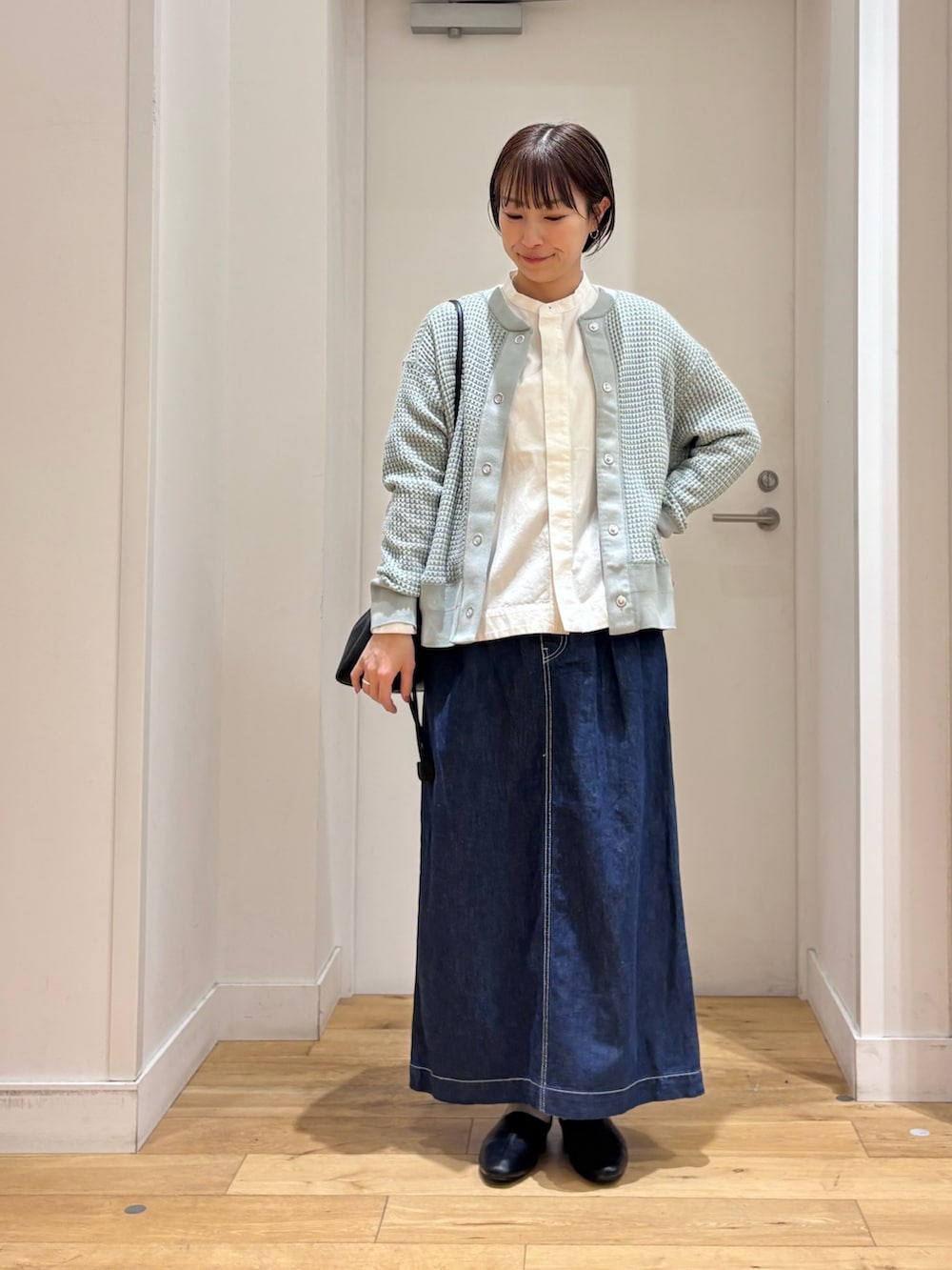 ホワイト系のシャツ/ブラウス、グリーン系のカーディガン/ボレロ、ブルー系のスカートを着用したレディースの春コーディネートの3枚目の写真