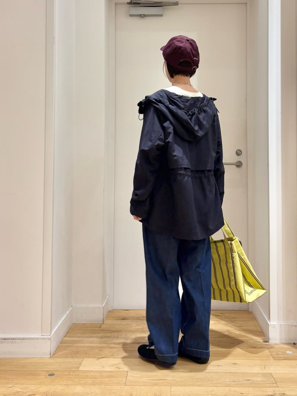 ブルー系のマウンテンパーカー、ホワイト系のTシャツ/カットソー、イエロー系のトートバッグを着用したレディースの春コーディネートの6枚目の写真