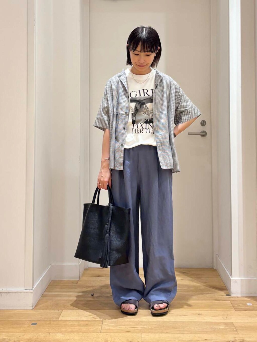 ブラック系のトートバッグ、グレー系のサンダル、ブルー系のその他パンツを着用したレディースの夏コーディネートの3枚目の写真