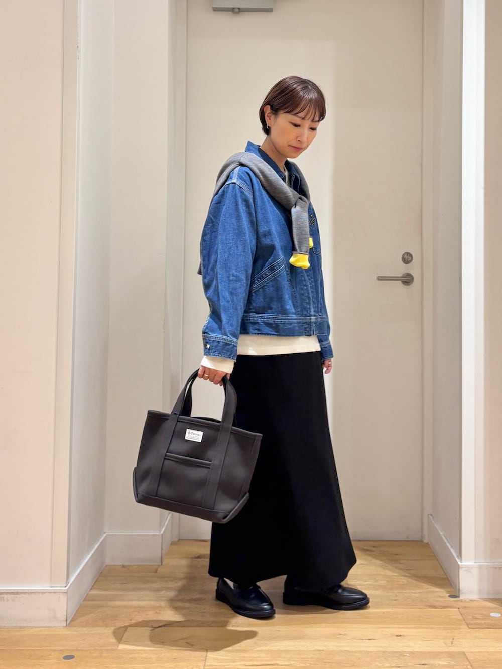 グレー系のカーディガン/ボレロ、ブルー系のデニムジャケット、ブラック系のローファーを着用したレディースの秋コーディネートの5枚目の写真