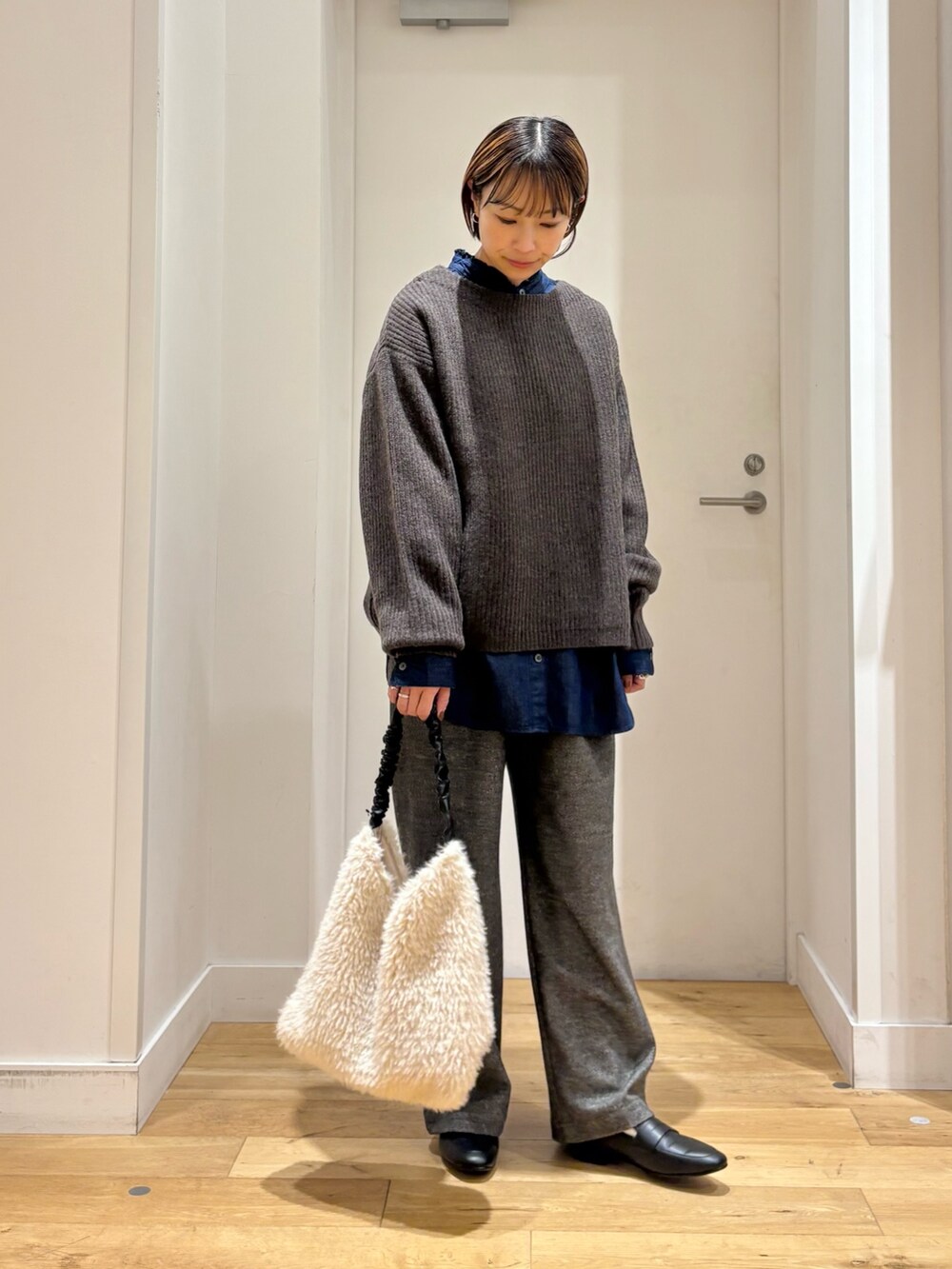 ブラウン系のニット/セーター、グレー系のその他パンツ、ブルー系のシャツ/ブラウスを着用したレディースの秋コーディネートの4枚目の写真