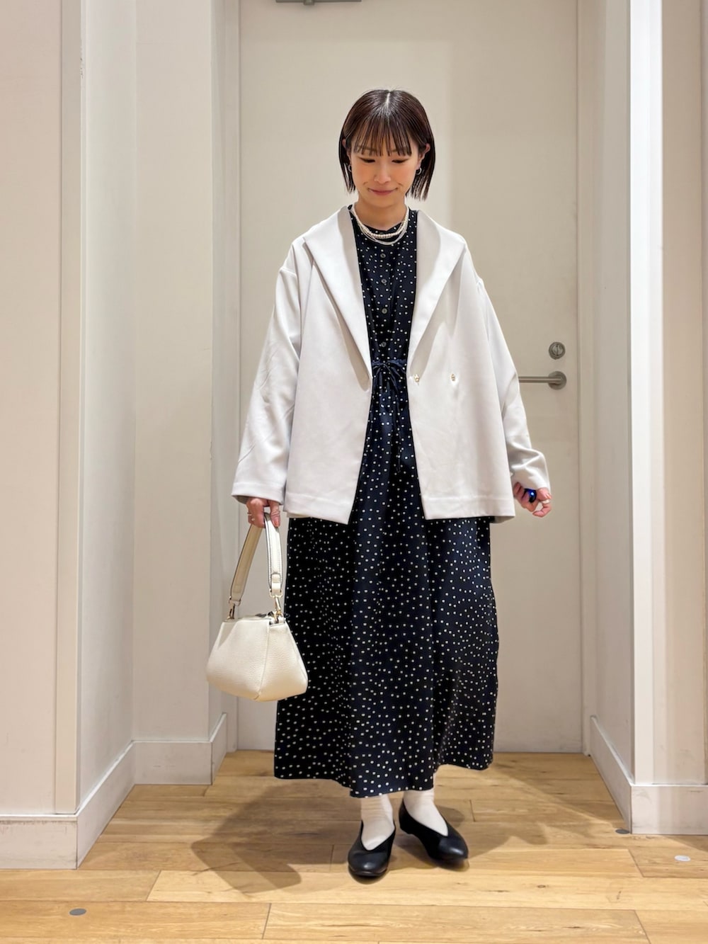 ブルー系のワンピース、グレー系のその他アウター、ホワイト系のショルダーバッグを着用したレディースの冬コーディネートの2枚目の写真